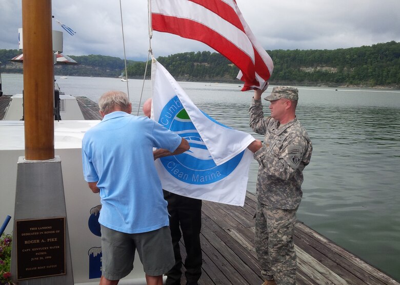 Nashville District Deputy Commander Maj. Christopher Burkhart (right) help raise the Clean Marina Banner with Charlie Denny, Conley Bottom Resort owner (right) and Marshal Jennings, Environmental Protection specialist, Nashville District. 
