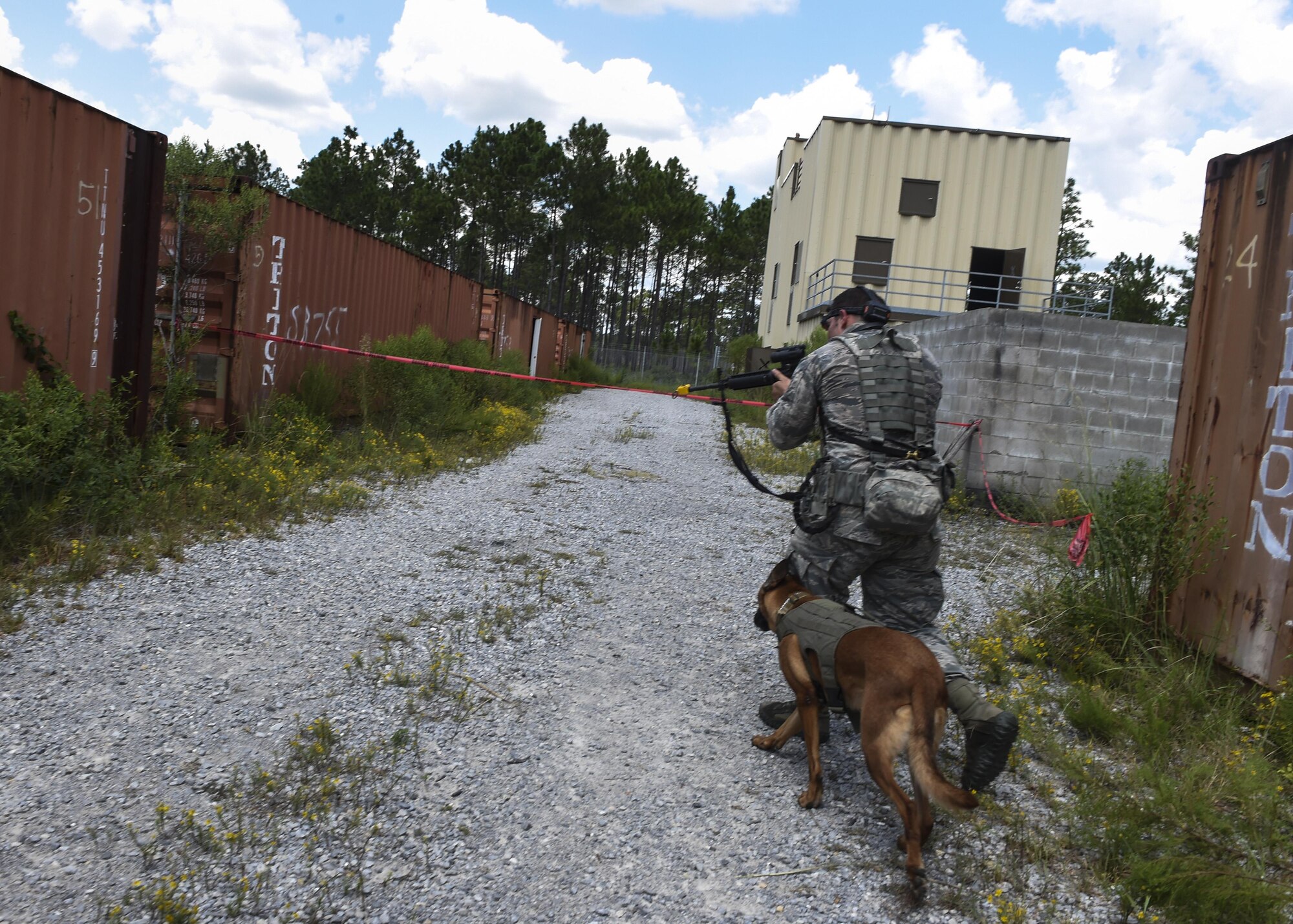 Staff Sgt. Justin Gooding, 1st Special Operations Security Forces Squadron military working dog handler, and MWD Eella work through a tactical obedience course, Sept. 4, 2015, at Eglin Range, Fla. The 1st Special Operations Security Forces Squadron military working dog section hosted a two-day competition, where participants were judged on tactical obedience, building search techniques, scouting and controlled aggression to see who the overall team was. (U.S. Air Force photo by Senior Airman Ryan Conroy/Released) 