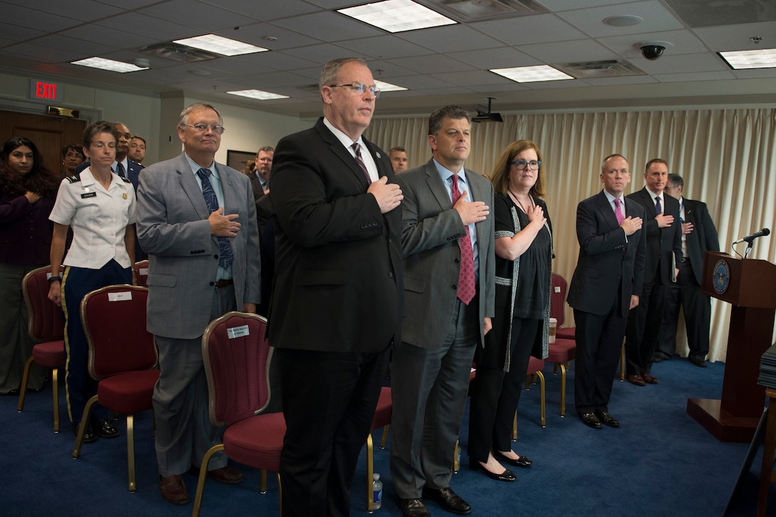 Deputy Defense Secretary Bob Work; Michael Rhodes, director of administration and management; and Patty Stonesifer, president and CEO at Martha's Table, place their hands over their hearts for the singing of the national anthem during the Combined Federal Campaign kickoff ceremony at the Pentagon, Sept. 15, 2015. The CFC, the federal government's workplace giving program, is the world's largest and most successful annual workplace charity campaign. DoD photo by U.S. Air Force Senior Master Sgt. Adrian Cadiz