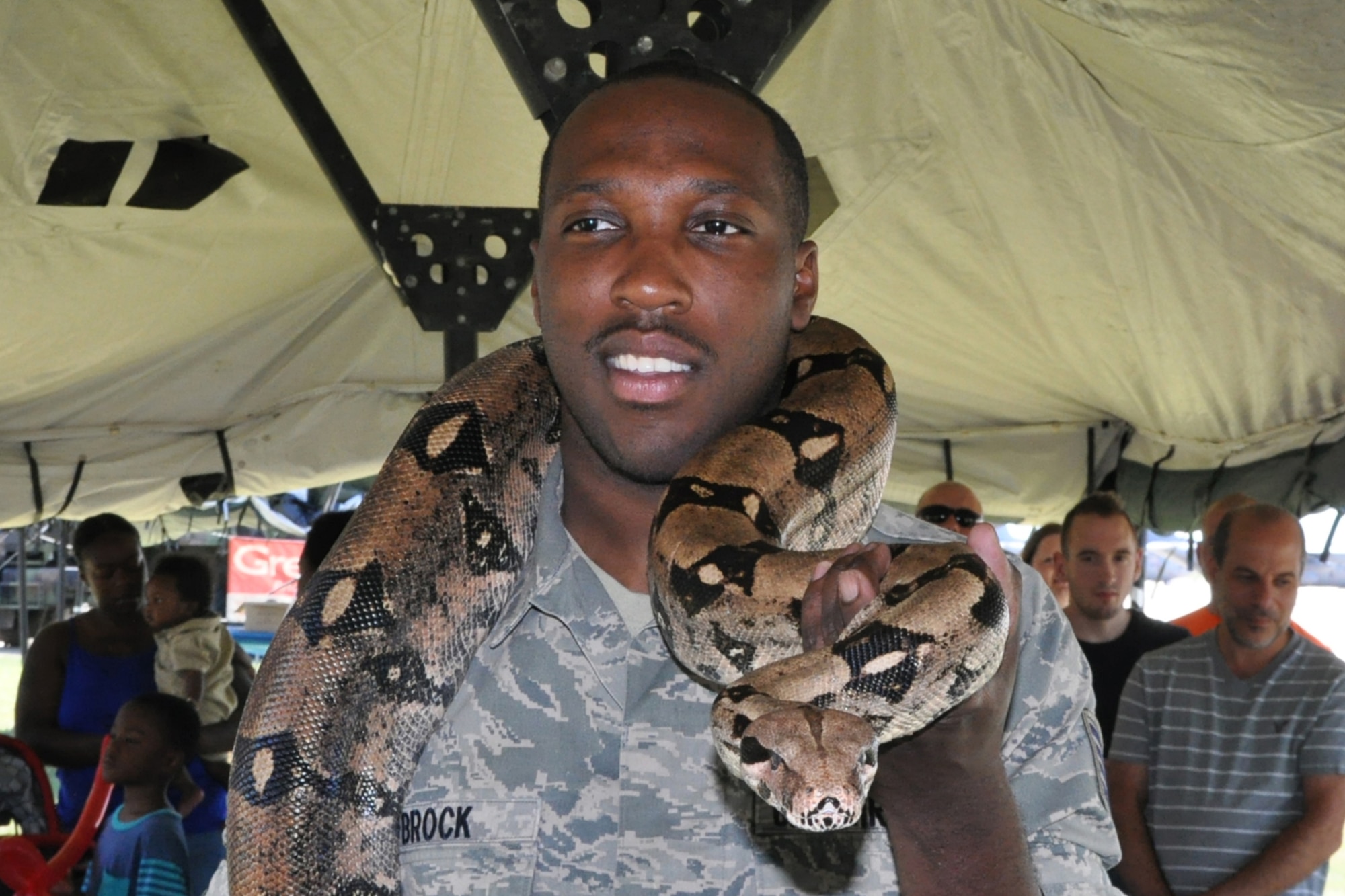 Staff Sgt. Donte Brock, an Aircrew Flight Equipment technician assigned to the 910th Operations Support Squadron, puts on a brave face while holding a large snake at a petting zoo set up during Family Day festivities held here, Aug. 2, 2015. Family day is an installation open house held for 910th Servicemembers and their families, designed to let Reserve families strengthen bonds and experience the home station of their Reservist loved one. (U.S. Air Force photo/Master Sgt. Bob Barko Jr.) 