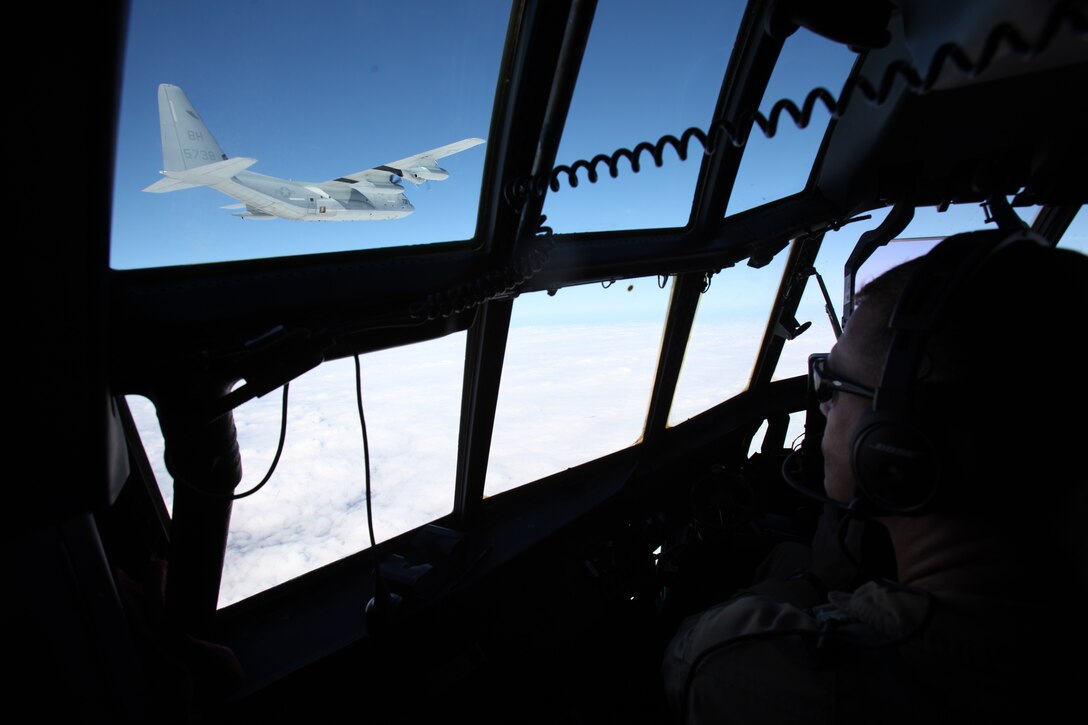 A KC-130J Super Hercules pilot gazes at a KC-130J maneuver through the skies during a division flight over eastern North Carolina, Sept. 1, 2015. Marine Aerial Refueler Transport Squadron 252 provides the Marine Air-Ground Task Force commander with air-to-air refueling, assault support and offensive air support, day and night under all weather conditions during expeditionary, joint, or combined operations. The squadron has supported these operations since its activation June 1, 1928. VMGR-252 remains the oldest continually active squadron in the Marine Corps. (U.S. Marine Corps photo by Lance Cpl. Jason Jimenez/Released)
