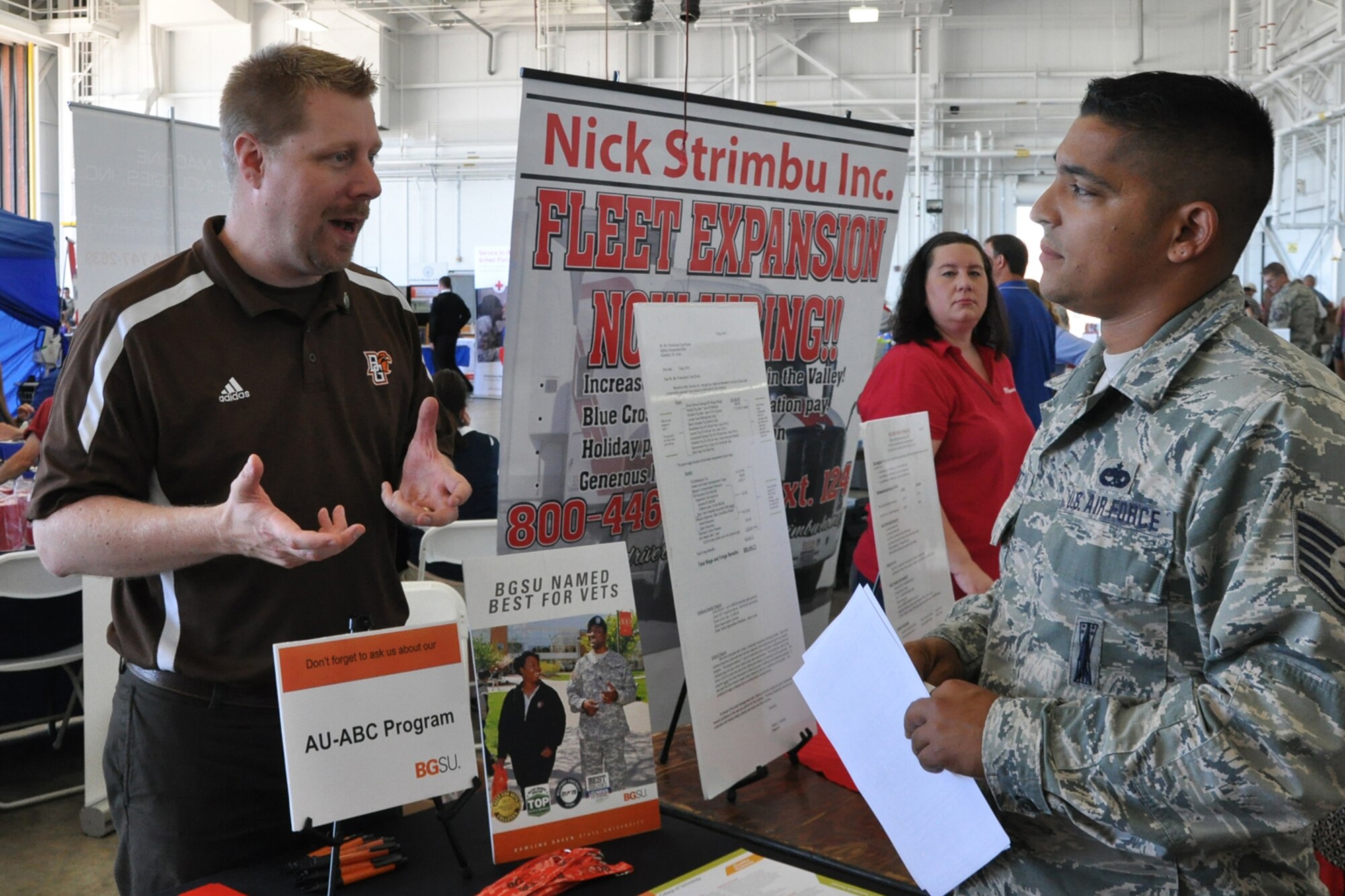 Tech. Sgt. Anthony Martinez, an electrical/environmental technician assigned to the 910th Aircraft Maintenance Squadron, talks with an exhibitor at a job and education fair during Family Day festivities held here, Aug. 2, 2015. Family day is an installation open house held for 910th Servicemembers and their families, designed to let Reserve families strengthen bonds and experience the home station of their Reservist loved one. (U.S. Air Force photo/Master Sgt. Bob Barko Jr.)