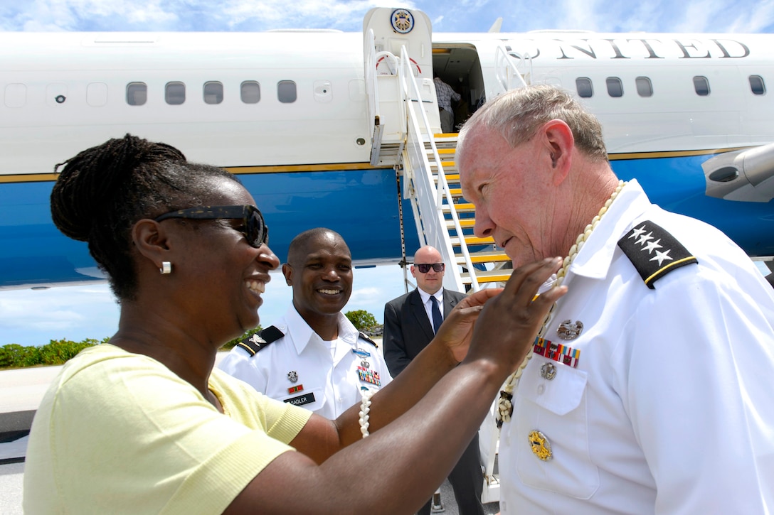 Monica Sadler, the wife of U.S. Army Col. Nestor Sadler, commander of U.S. Army Garrison-Kwajalein Atoll, gives a shell necklace to U.S. Army Gen. Martin E. Dempsey, chairman of the Joint Chiefs of Staff, upon his arrival on Bucholz Army Airfield, Kwajalein Atoll, Marshall Islands, Feb. 21, 2015. U.S. Army Col. Nestor Sadler, center, looks on. DoD photo by D. Myles Cullen
