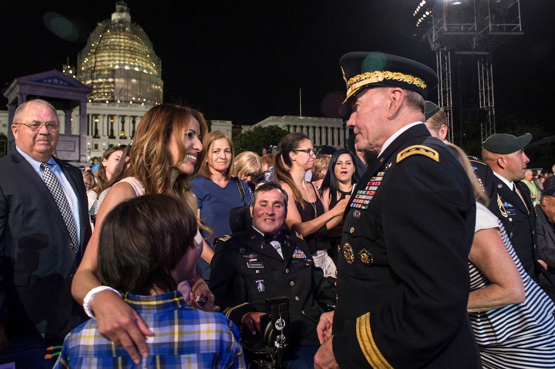 Army Gen. Martin E. Dempsey, chairman of the Joint Chiefs of Staff, greets wounded warrior Romulo Camargo, a retired Army chief warrant officer, and his family at the 26th National Memorial Day Concert at the U.S. Capitol in Washington, D.C., May 24, 2015. The concert included musical performances, documentary footage and dramatic readings to honor the fallen and comfort the grieving. DoD photo by U.S. Navy Petty Officer 1st Class Daniel Hinton