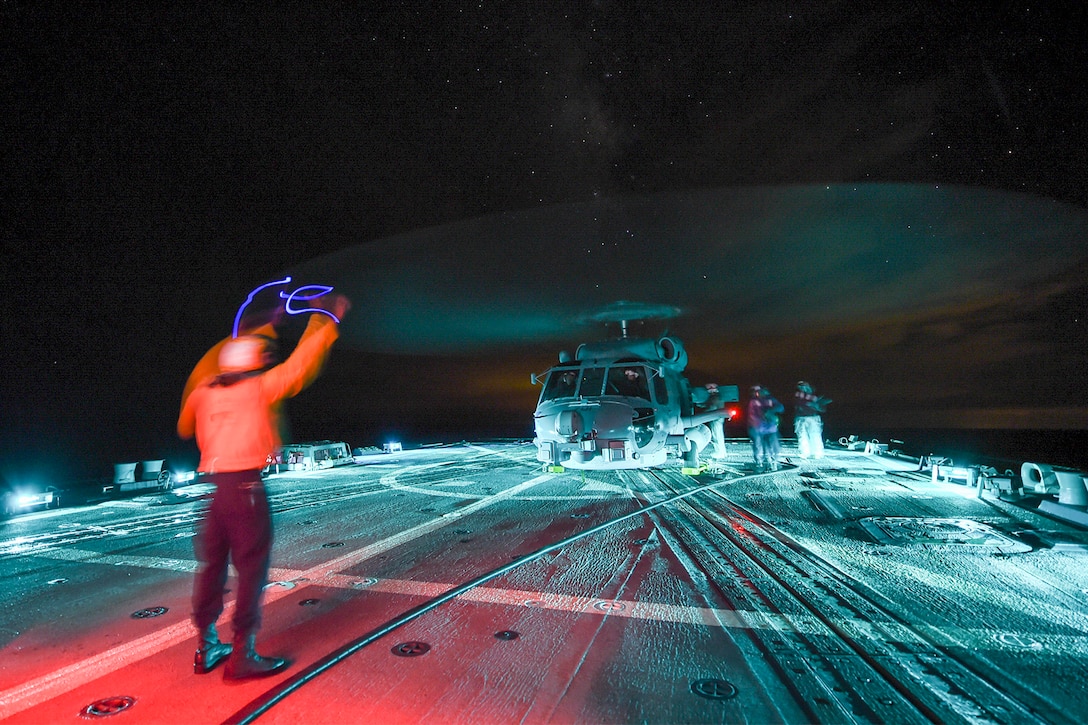Sailors aboard the USS Gravely refuel an MH-60R Seahawk helicopter during night flight operations in the Atlantic Ocean, Sept. 13, 2015. The Gravely is underway participating in a composite training exercise with the Harry S. Truman Carrier Strike Group. U.S. Navy photo by Petty Officer Seaman L.E. Skelton