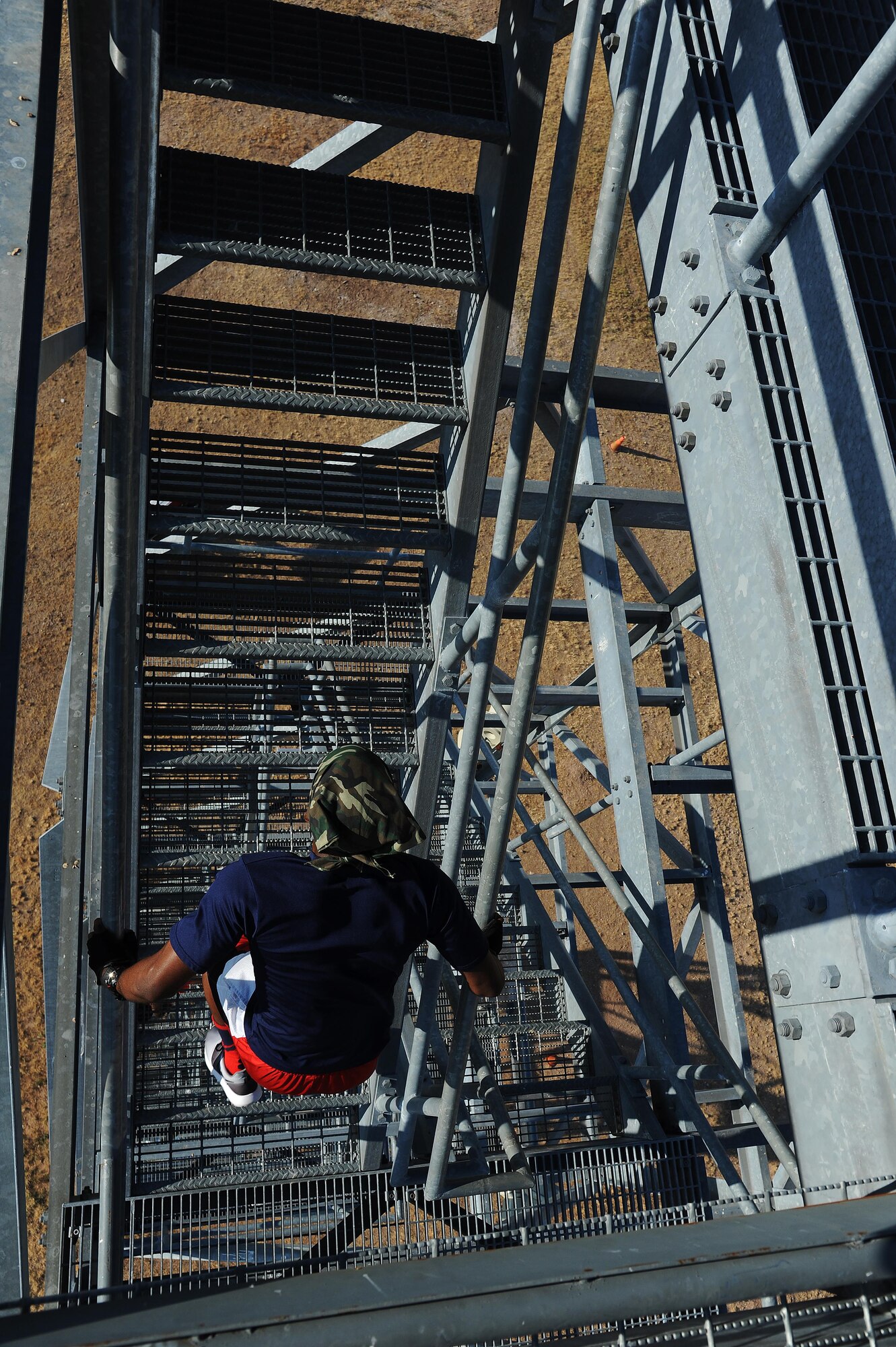 Jamarrio Fluker, 315th Training Squadron student, climbs the final steps to the top of a 9-story tower at Goodfellow Air Force Base, Sept. 12, 2015. The tower was one of the final obstacles of the event before participants had to run back to the finish line. (U.S. Air Force photo by Airman Caelynn Ferguson/Released)
