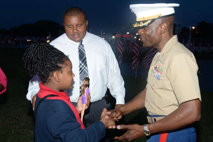 Col. James C. Carroll III, commanding officer, Marine Corps Logistics Base Albany, joins members of the community, both young and old, military members, veterans, first responders and local dignitaries to pay tribute to those who lost their lives during the tragic events of 9/11. The Patriots Field of Flags is an annual event sponsored by American Legion Post 30 and for the 14th year, was held in front of the Albany Mall, Sept. 11.