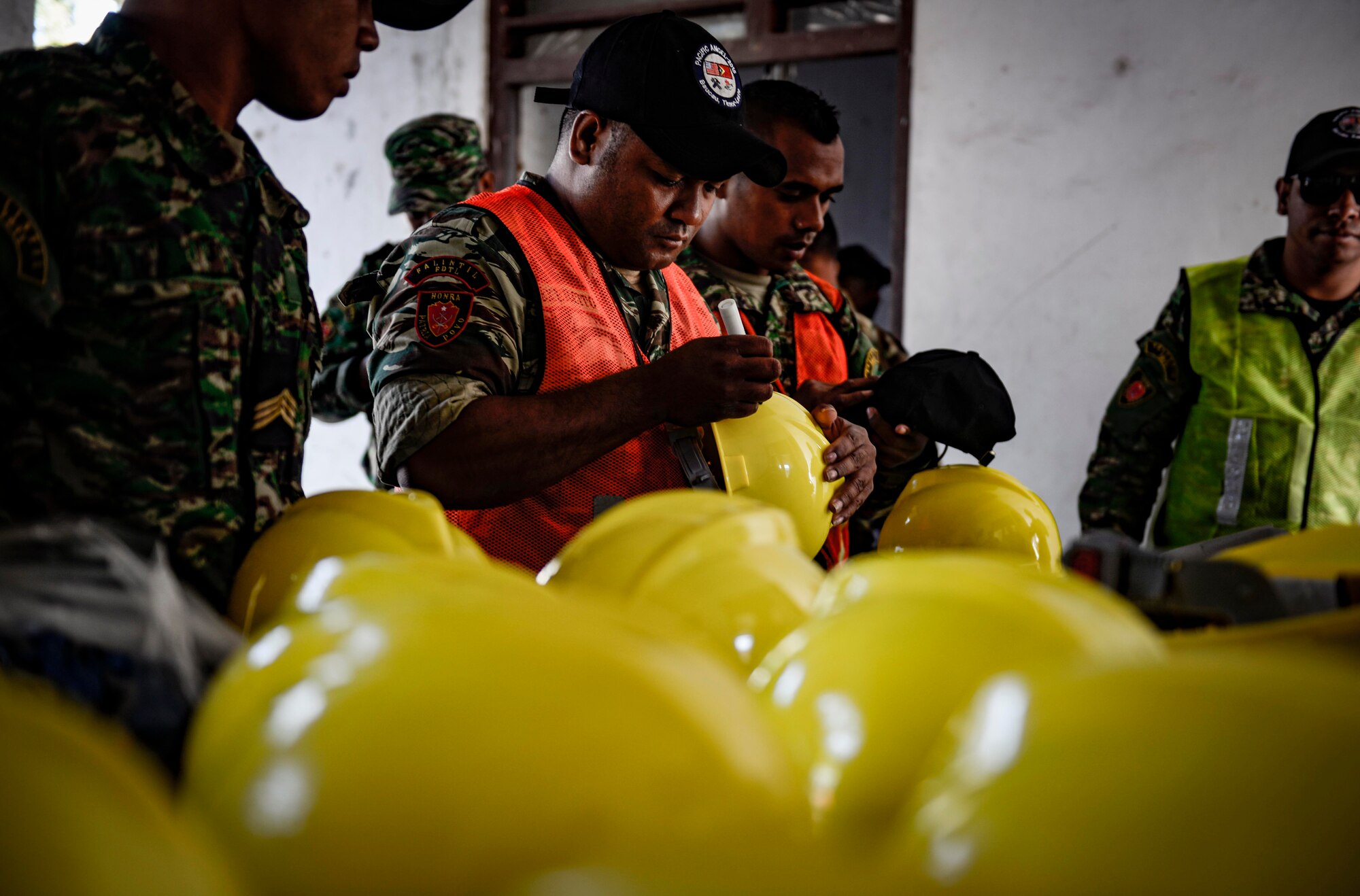 Members of the Falintil Forças de Defesa de Timor-Leste, write their names on protective helmets before beginning work on a Pacific Angel 15-2 construction project Sept. 5, 2015, in Baucau, Timor-Leste. Efforts undertaken during Pacific Angel help multilateral militaries in the Pacific improve and build relationships across a wide spectrum of civic operations, which bolsters each nation’s capacity to respond and support future humanitarian assistance and disaster relief operations. (U.S. Air Force photo by Staff Sgt. Alexander W. Riedel/Released)