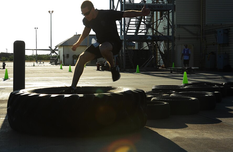 Josh Jones, San Angelo Special Weapons and Tactics patrol officer, leaps through the final stretch of the tire run obstacle during the Blood, Sweat and Stairs Competition at Goodfellow Air Force Base, Texas, Sept. 12, 2015. The competition included a variety of high intensity leg workouts between climbing multiple staircases. (U.S. Air Force photo by Airman Caelynn Ferguson)