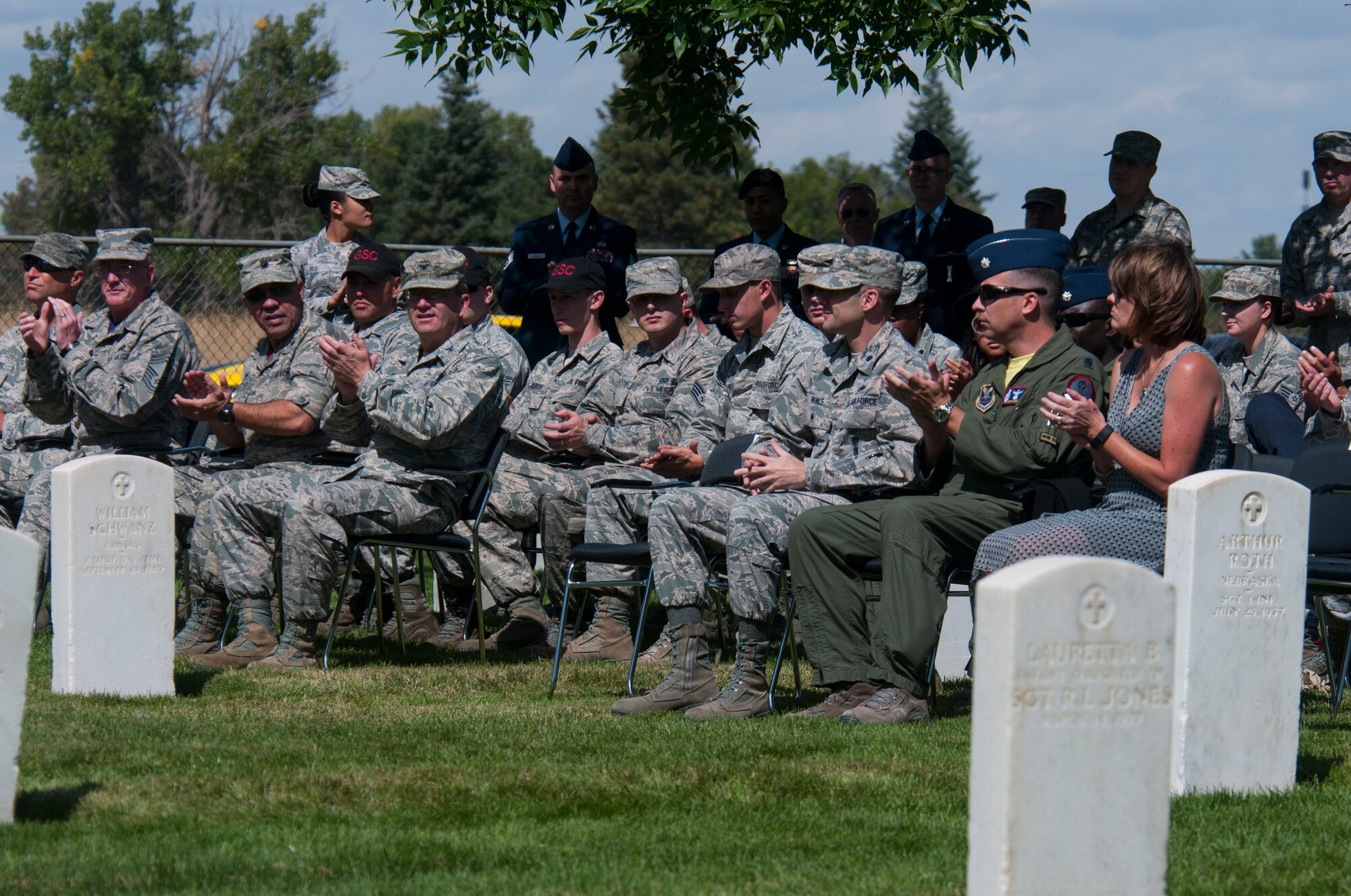 A crowd, gathered in the F.E. Warren Air Force Base, Wyo., cemetery, claps for the 90th Missile Wing Honor Guard ceremonial guardsmen being inducted during a ceremony there Sept. 11, 2015. Wing leadership watched the new ceremonial guardsmen perform a funeral detail with an empty casket to showcase the professionalism with which they will perform military funerals while in the honor guard. (U.S. Air Force photo by Senior Airman Jason Wiese)
