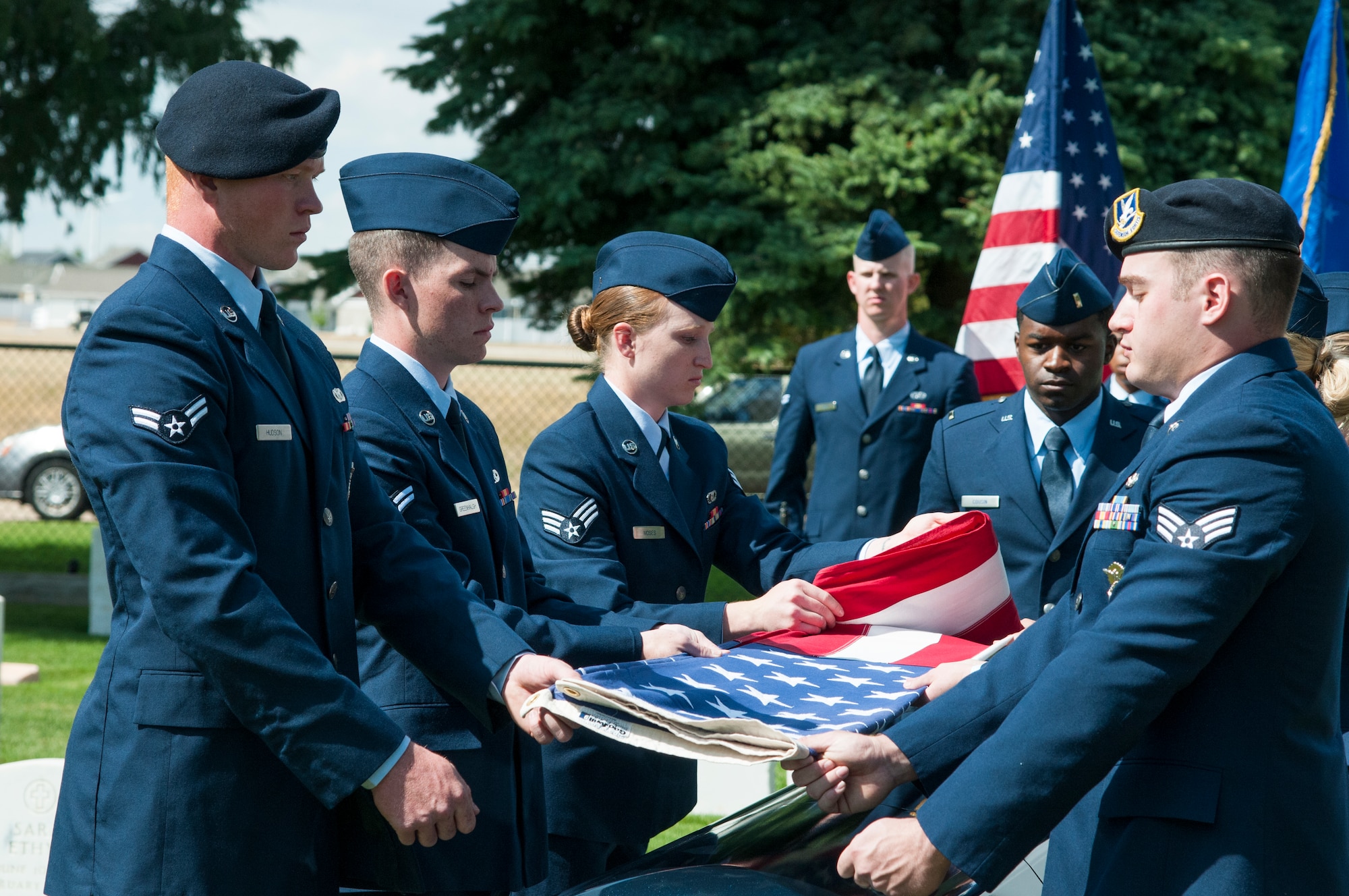 New 90th Missile Wing ceremonial guardsmen demonstrate the proper folding of the American Flag for military funerals during a graduation ceremony Sept. 11, 2015, in the F.E. Warren Air Force Base, Wyo., cemetery. During military funerals, the folded flag is presented to a deceased Airman’s next-of-kin. (U.S. Air Force photo by Senior Airman Jason Wiese)