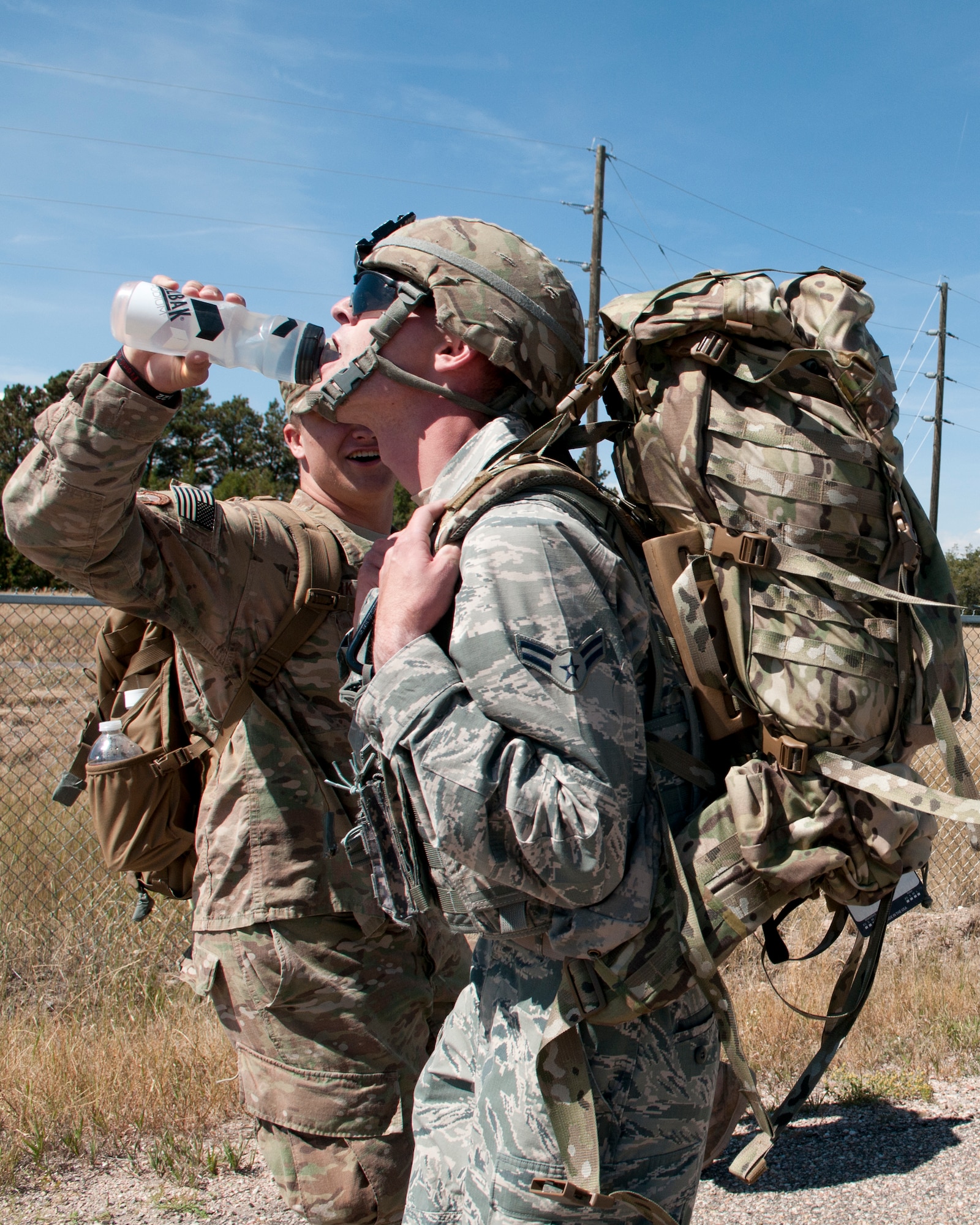 Airman 1st Class Travis Summers, 790th Missile Security Forces Squadron member, receives a drink of water from a fellow Airmen during the ruck run portion of the 2015 Crow Creek Challenge, Sept. 11, 2015, on F.E. Warren Air Force Base, Wyo. Each competitor carried a 40 pound ruck sack along a 1.8 mile route. (U.S. Air Force photo by Airman 1st Class Malcolm Mayfield)