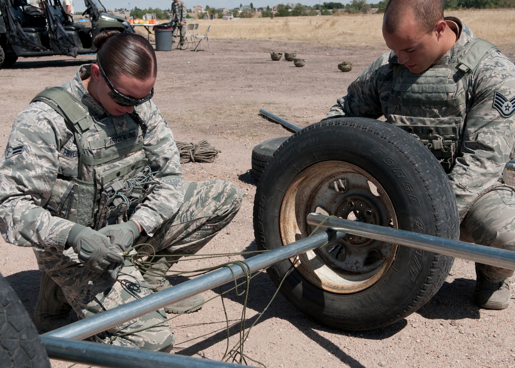 Airman 1st Class Samantha Frydenlund and Staff Sgt. Joshua Washington, 790th Missile Security Forces Squadron members, work together during the Team Building/Obstacle Move portion of the 2015 Crow Creek Challenge, Sept. 11, 2015, on F.E. Warren Air Force Base, Wyo. The teams were tasked with constructing an improvised vehicle out of several materials to move eight sandbags from one location to another. (U.S. Air Force photo by Airman 1st Class Malcolm Mayfield)