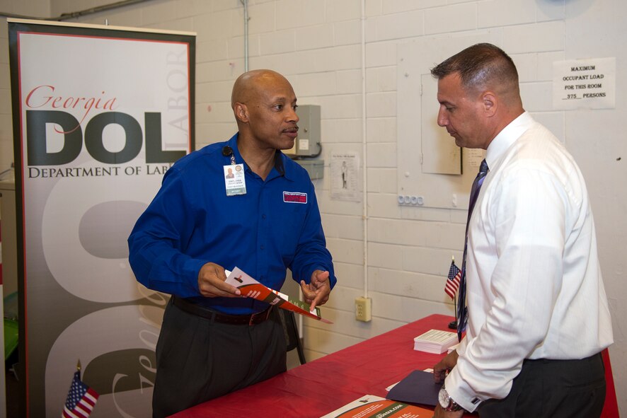Tony McKenzie, Georgia Department of Labor services specialist, shows U.S. Air Force Master Sgt. John Lamp, 23d Force Support Squadron vow compliance coordinator, a brochure about resume matching during Moody’s Transition Expo Sept. 10, 2015, at Moody Air Force Base, Ga. The GDL co-sponsored the event and assisted veterans while they navigated their job search. (U.S. Air Force photo by Airman 1st Class Greg Nash/Released) 
