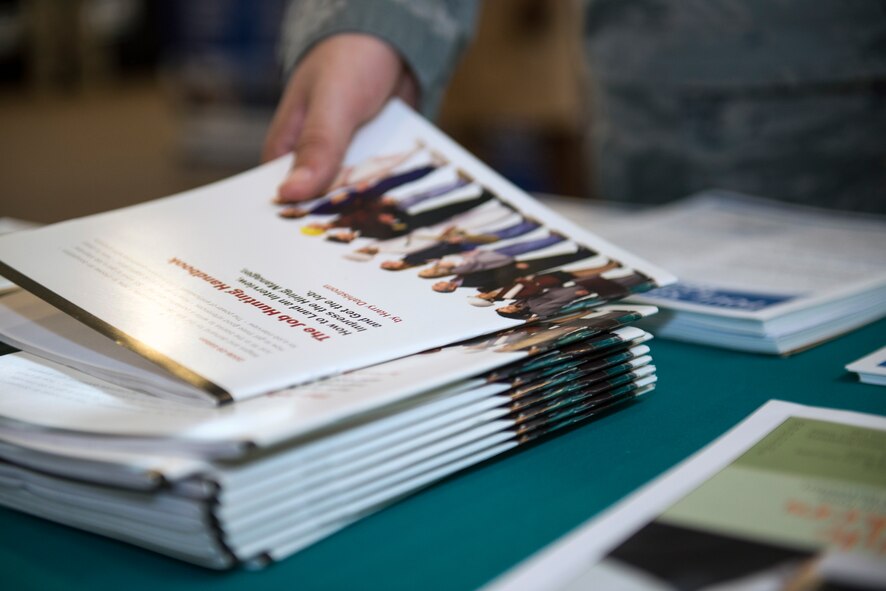 An Airman picks up a job opportunity booklet during Moody’s Transition Expo Sept. 10, 2015, at Moody Air Force Base, Ga. Approximately 700 job openings were available from more than 50 organizations that were in attendance. (U.S. Air Force photo by Airman 1st Class Greg Nash/Released) 