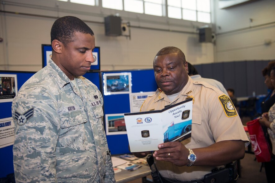 U.S. Air Force Senior Airman Deandre Greer (left), 824th Base Defense Squadron fire team member, reviews a pamphlet alongside Calvin Burgess, local law enforcement officer, during Moody’s Transition Expo Sept. 10, 2015, at Moody Air Force Base, Ga. Employers in attendance emphasized the importance of adequate resumes, good references, obtaining proper certifications, interaction skills and professionalism as ways to increase their chances of being hired. (U.S. Air Force photo by Airman Greg Nash/Released)  