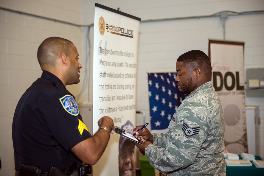 U.S. Air Force Staff Sgt. Brandon Abercrombie (right), 347th Operations Support Squadron assistant NCO in charge of aircrew flight equipment , fills out contact information for Sergeant Julius Few, local law enforcement recruiting unit supervisor, at Moody’s Transition Expo Sept. 10, 2015, at Moody Air Force Base, Ga. The fair allowed attendees to connect with employers, inquire about job openings and learn about interview opportunities. (U.S. Air Force photo by Airman 1st Class Greg Nash/Released) 