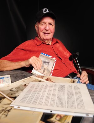 Retired U.S. Army 1st Sgt. Ray Frazier poses with memorabilia at Davis-Monthan Air Force Base, Ariz., Aug. 28, 2015. Frazier was captured by Chinese and North Korean soldiers during the Korean War and held as a prisoner from 1951 to 1953. His memorabilia from his time as a POW will be on display during the POW/MIA Remembrance Ceremony Sept. 18, at the Pima Air and Space Museum. (U.S. Air Force photo by Senior Airman Cheyenne A. Powers/Released)