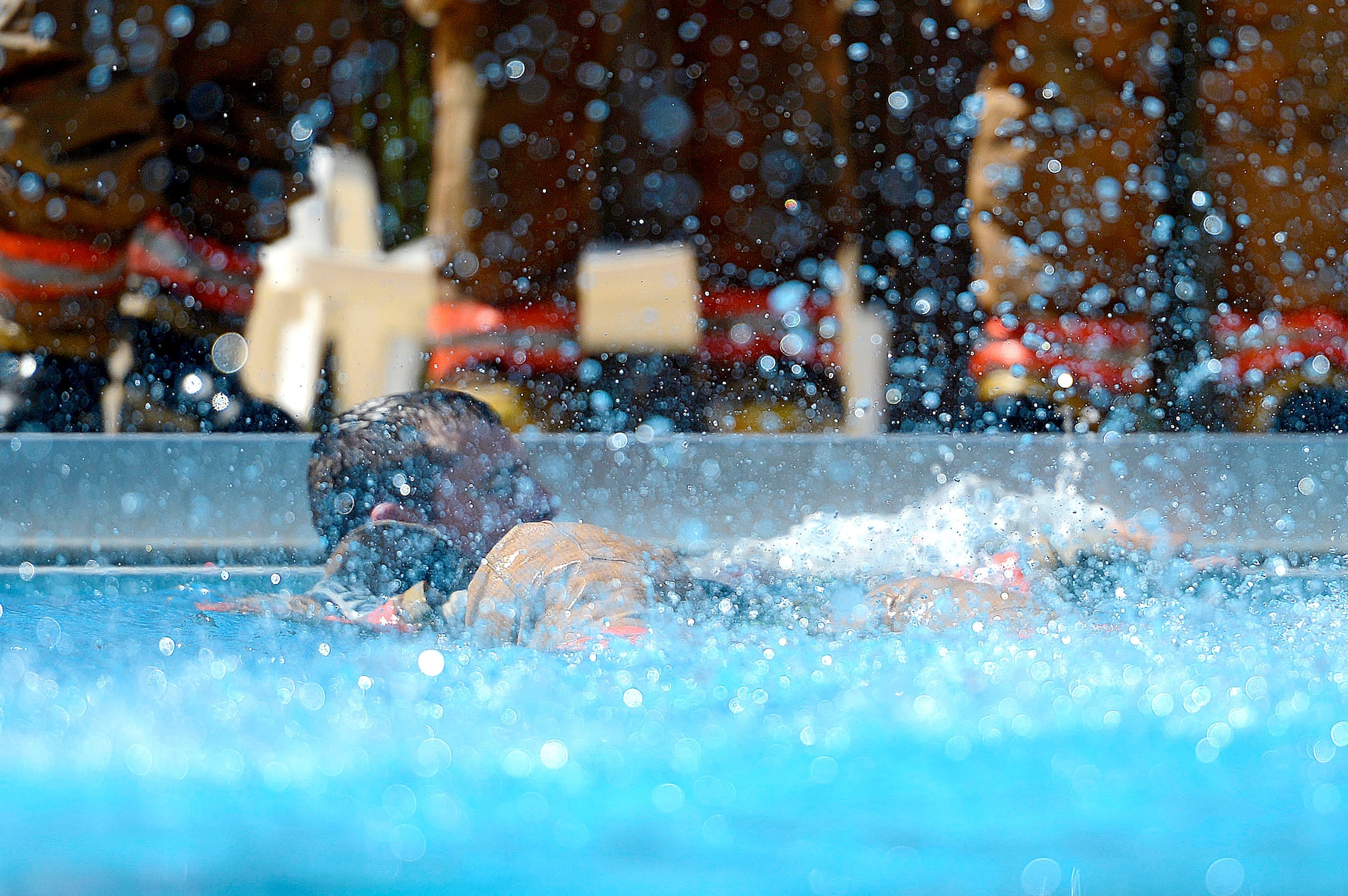 U.S. Air Force Staff Sgt. Christopher Crusius, 20th Civil Engineer Squadron firefighter, surfaces from the water during firefighter water survival training at Shaw Air Force Base, S.C., Sept. 10, 2015. Throughout the training, firefighters learned techniques to stay afloat and practiced swimming while wearing turnout gear in the water. (U.S. Air Force photo by Senior Airman Jensen Stidham/Released)