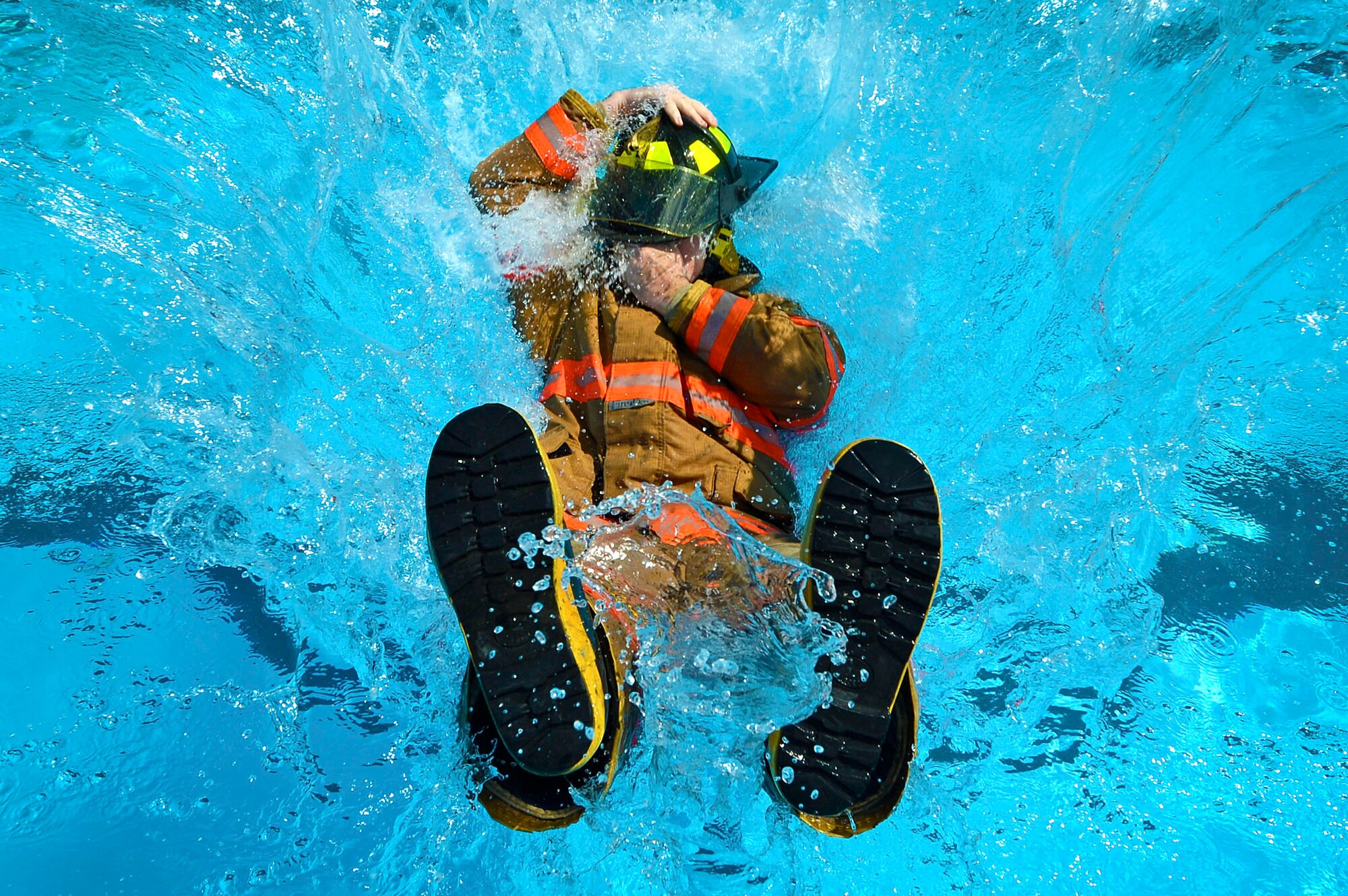 A 20th Civil Engineer Squadron firefighter falls into water during firefighter water survival training at Shaw Air Force Base, S.C., Sept. 10, 2015. Airmen learned water entry, rescue survival, and exiting procedures to ensure their safety in the event of water immersion. (U.S. Air Force photo by Senior Airman Jensen Stidham/Released)