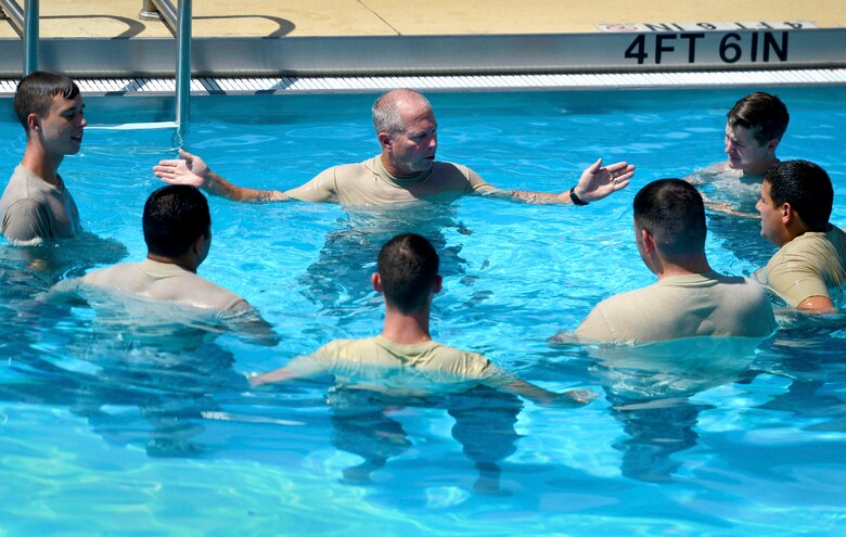 U.S. Air Force Senior Master Sgt. Randy Gardner (center), 20th Civil Engineer Squadron deputy fire chief, briefs Airmen during firefighter water survival training at Shaw Air Force Base, S.C., Sept. 10, 2015. Before doning their turnout gear, firefighters learned basic water safety to prevent training mishaps. (U.S. Air Force photo by Senior Airman Jensen Stidham/Released)