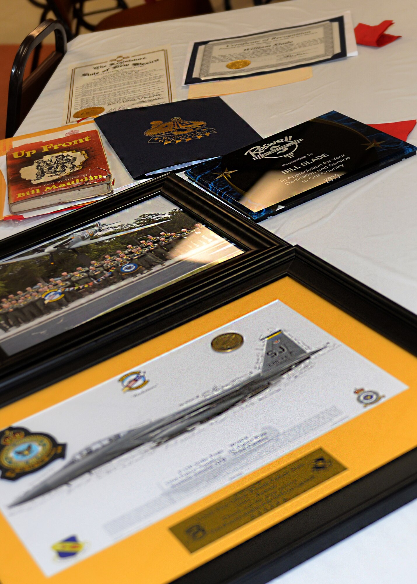 Members of the 336th Fighter Squadron presented several gifts to William “Bill” Slade during his 100th birthday celebration, Sept. 3, 2015, at Roswell Air Force Base, New Mexico. Slade was given framed pictures of squadron members in front of a static Spitfire as well as an F-15E Strike Eagle signed by all the current Rocketeers. (Courtesy photo)