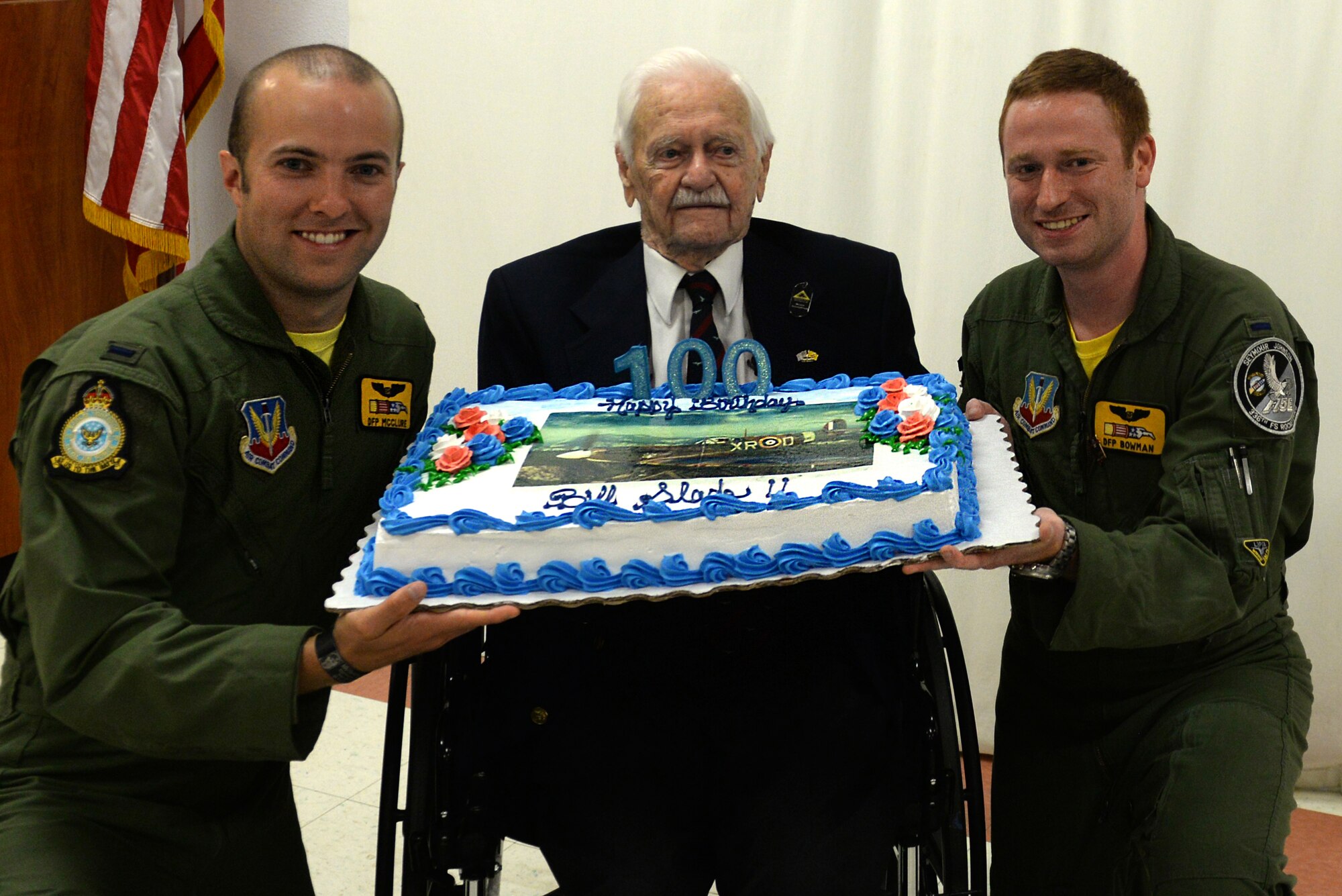 1st Lt. Chadwick McClure (left) and 1st Lt. Benjamin Bowman (right), both officers with the 336 FS, William “Bill” Slade his birthday cake during his 100th birthday celebration, Sept. 3, 2015, at Roswell Air Force Base, New Mexico. Slade originally flew the Spitfire for the Royal Air Force as part of the 133rd Pursuit Squadron, which is currently known as the 336th FS.  (Courtesy photo)
