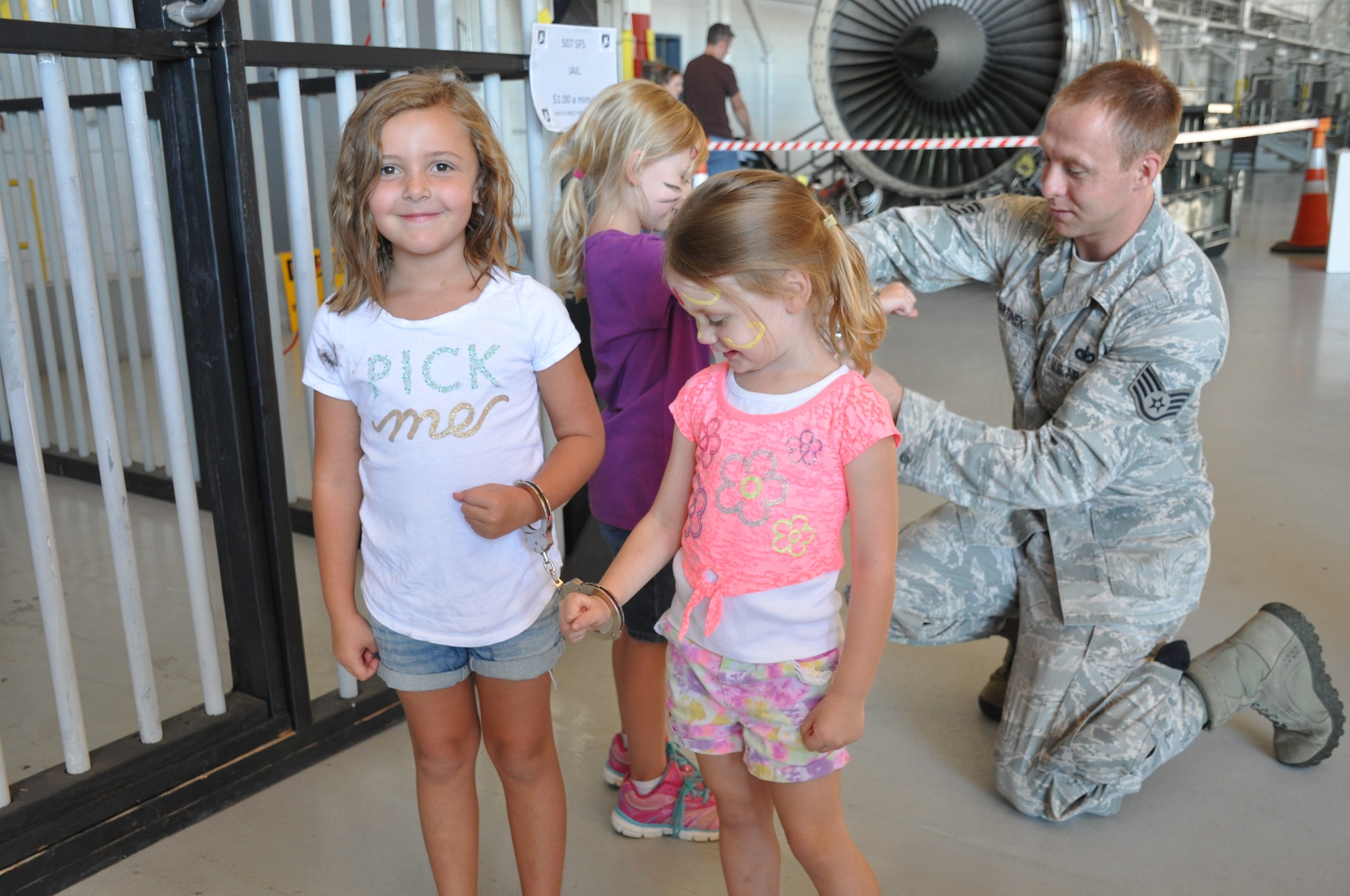 Staff Sgt. Samuel Martinek of the 507th Security Forces Squadron handcuffs kids to put them in jail during the 507th Air Refueling Wing Family Day celebration Sept. 12, 2015, at Tinker Air Force Base, Okla. Family Day is held on the Saturday of the Unit Training Assembly and gives Reservists and their families time to come together and build camaraderie. (U.S. Air Force photo by Tech. Sgt. Lauren Gleason)