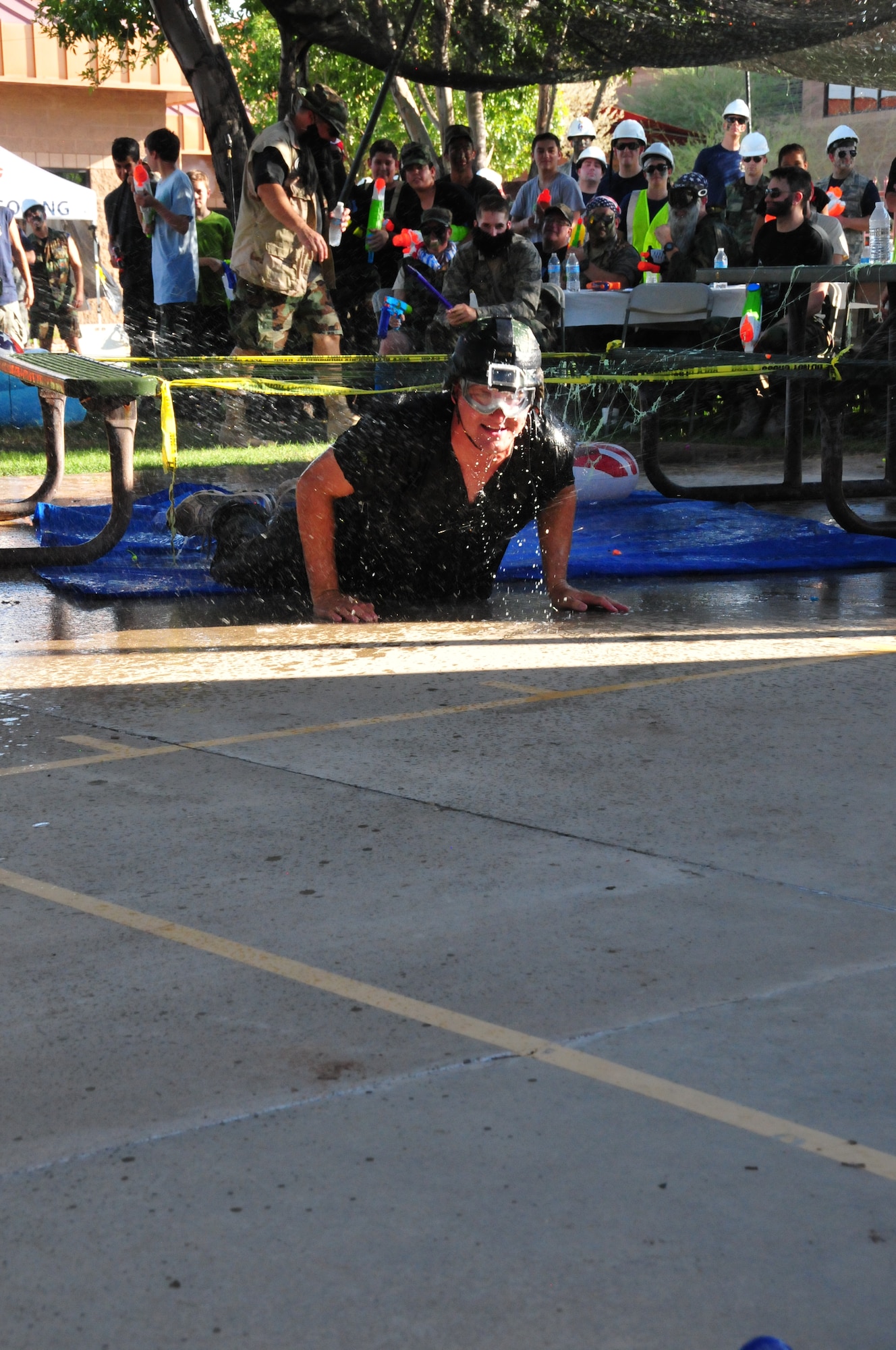 Master Sgt. Don Lewis, 161st Medical Group first sergeant, low crawls through the obstacle course on his way to the grog bowl at the wing’s first-ever combat dining-in, Sept. 12, 2015, at Phoenix Sky Harbor Air National Guard Base. The combat dining in is a time-honored Air Force tradition that is making its way back into units across the Air National Guard. (U.S. Air National Guard photo by Master Sgt. Kelly Deitloff)
