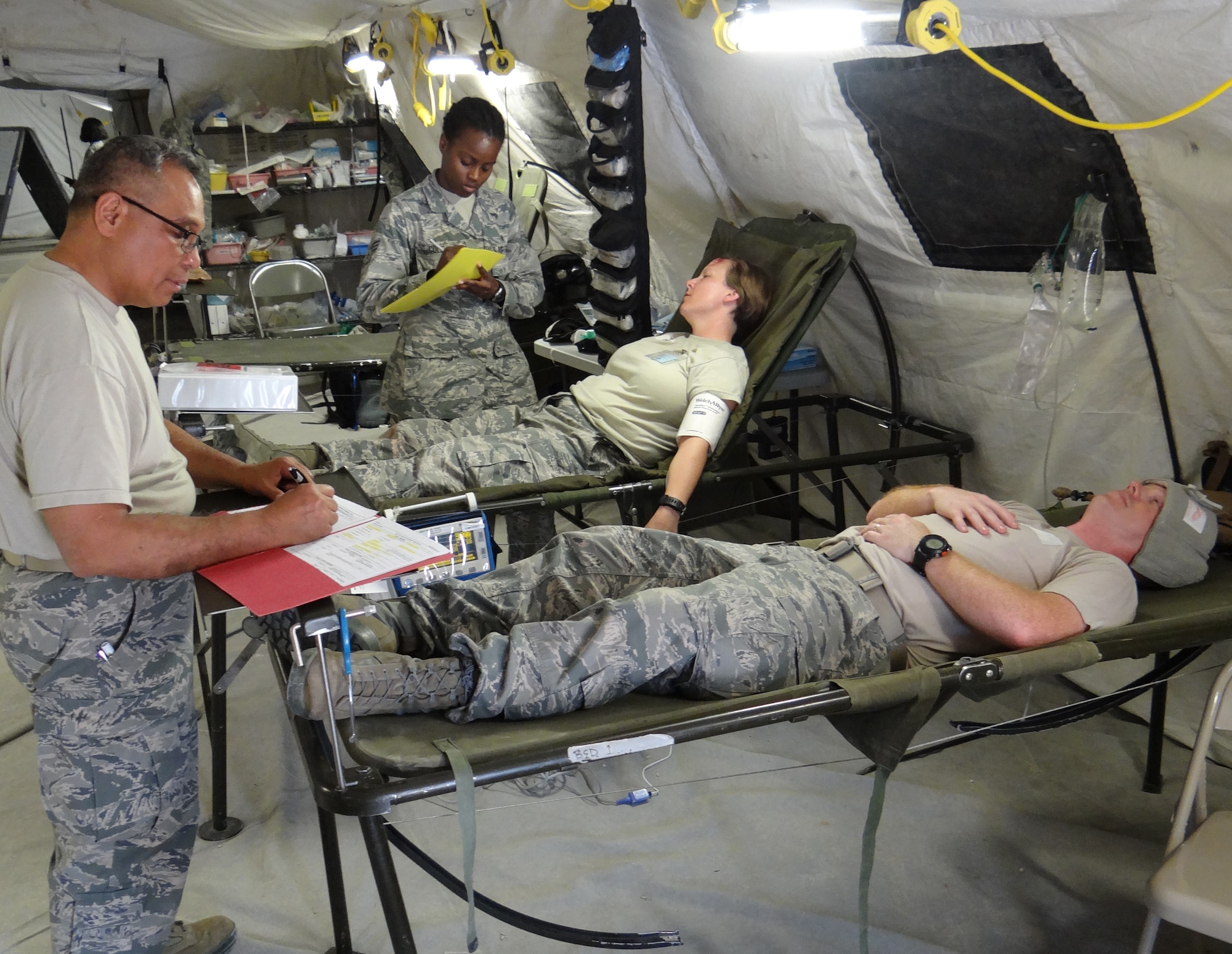 (Left to right) Lt. Col. Butch Tubera, 301st Medical Squadron internal medicine physician, and Senior Airman Vanessa Cole, 301 MDS aerospace medicine technician, review patients’ records during a training scenario June 25 in an Expeditionary Medical Support facility at the Medical Readiness Training Center, Camp Bullis, San Antonio, Texas. Nearly 100 Reservists trained June 22-26 at the Medical Readiness Training Center for mandatory deployment training. Reservists established and operated an Expeditionary Medical Support (EMEDS) facility complete with an emergency room, ambulatory care, lab, radiology, pharmacy, Bio-Environmental/public health, dental, operating room, intensive care, nursing care and command capabilities. (U.S. Air Force photo/Chief Master Sgt. Robert Poisson)