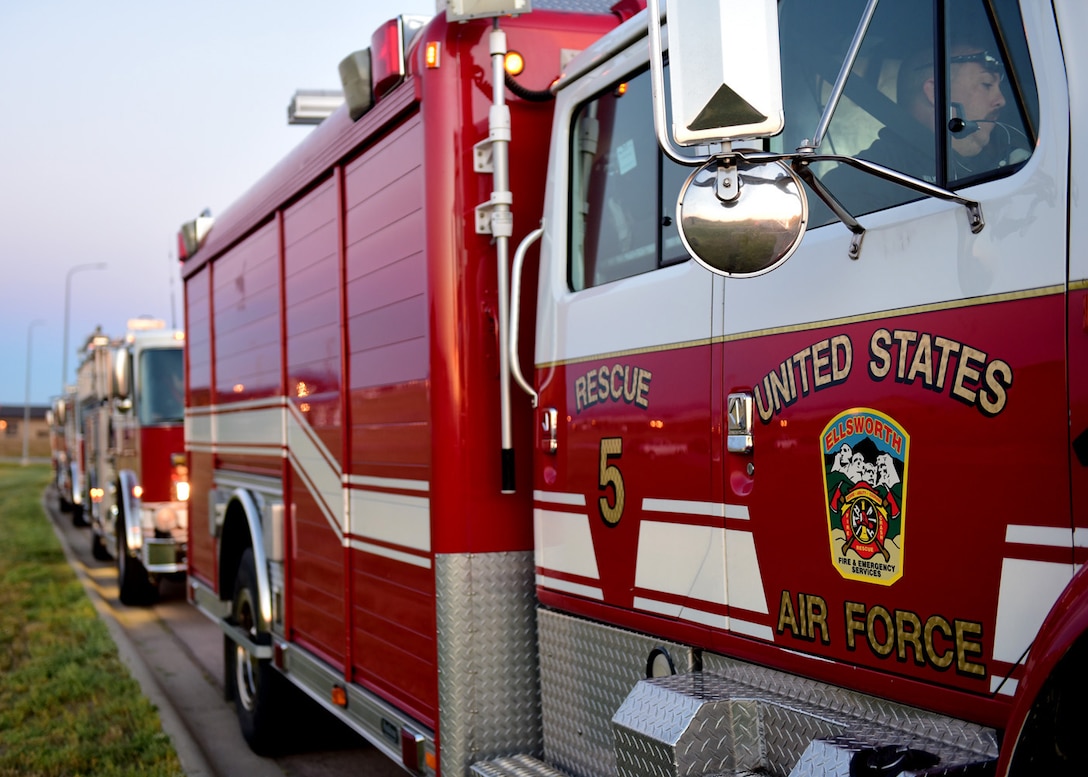 Base fire trucks line the street in front of the installation flag pole during a 9/11 Memorial Ceremony, at Ellsworth Air Force Base, S.D., Sept 11, 2015. The ceremony began with the raising of the flag and concluded with the lowering of the flag to half-staff honoring the victims of the terrorist attacks on Sept. 11, 2001. (U.S. Air Force photo by Airman 1st Class James L. Miller/Released)