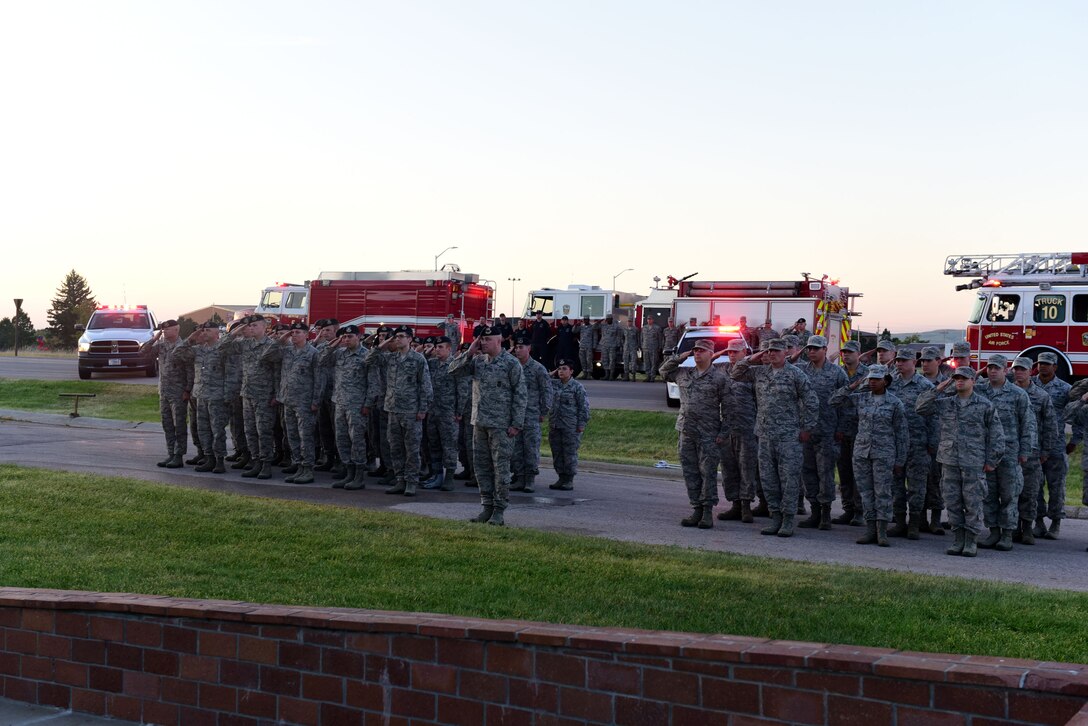 Ellsworth Airmen from the 28th Security Forces Squadron and the 28th Civil Engineer Squadron render a salute during a 9/11 Memorial Ceremony at Ellsworth Air Force Base, S.D., Sept. 11, 2015. Airmen gathered together in remembrance of the men and women who lost their lives during the attacks on the Pentagon, the Twin Towers and the failed hijacking of United Airlines flight 93, Sept. 11, 2001. (U.S. Air Force photo by Airman 1st Class James L. Miller/Released)