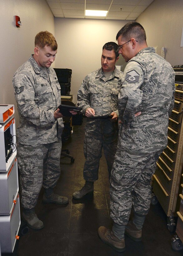 Staff Sgt. Matthew Mueller, 28th Maintenance Group e-tools functional system administrator (left), Master Sgt. Mark Masse, Headquarters Air Combat Command acquisitions and financial program manager and Master Sgt. Joshua Coddington, 28th Aircraft Maintenance Squadron sortie support section chief, discuss the newly implemented iPad operations at Ellsworth Air Force Base, S.D., Sept. 9, 2015. Nearly 300 iPads were provided to Ellsworth by ACC, with 4,250 being distributed across the command. (U.S. Air Force photo by Senior Airman Rebecca Imwalle/Released)