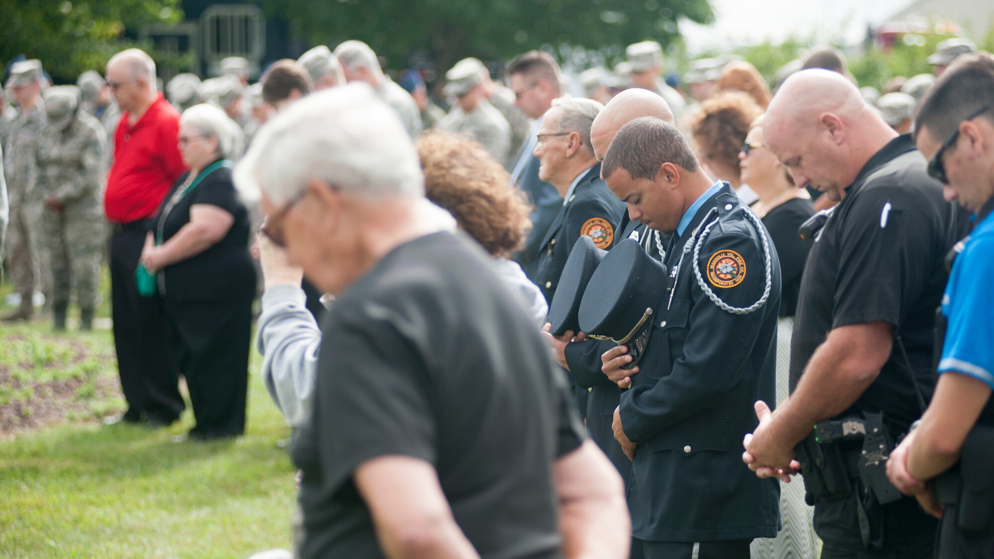 Magnolia Fire Company firefighters bow their heads for the invocation during the 9/11 memorial service Sept. 11, 2015, at the Air Mobility Command Museum on Dover Air Force Base, Del. Members of local firefighter communities showed their respect by participating in the memorial. (U.S. Air Force photo/Staff Sgt. Jared Duhon)