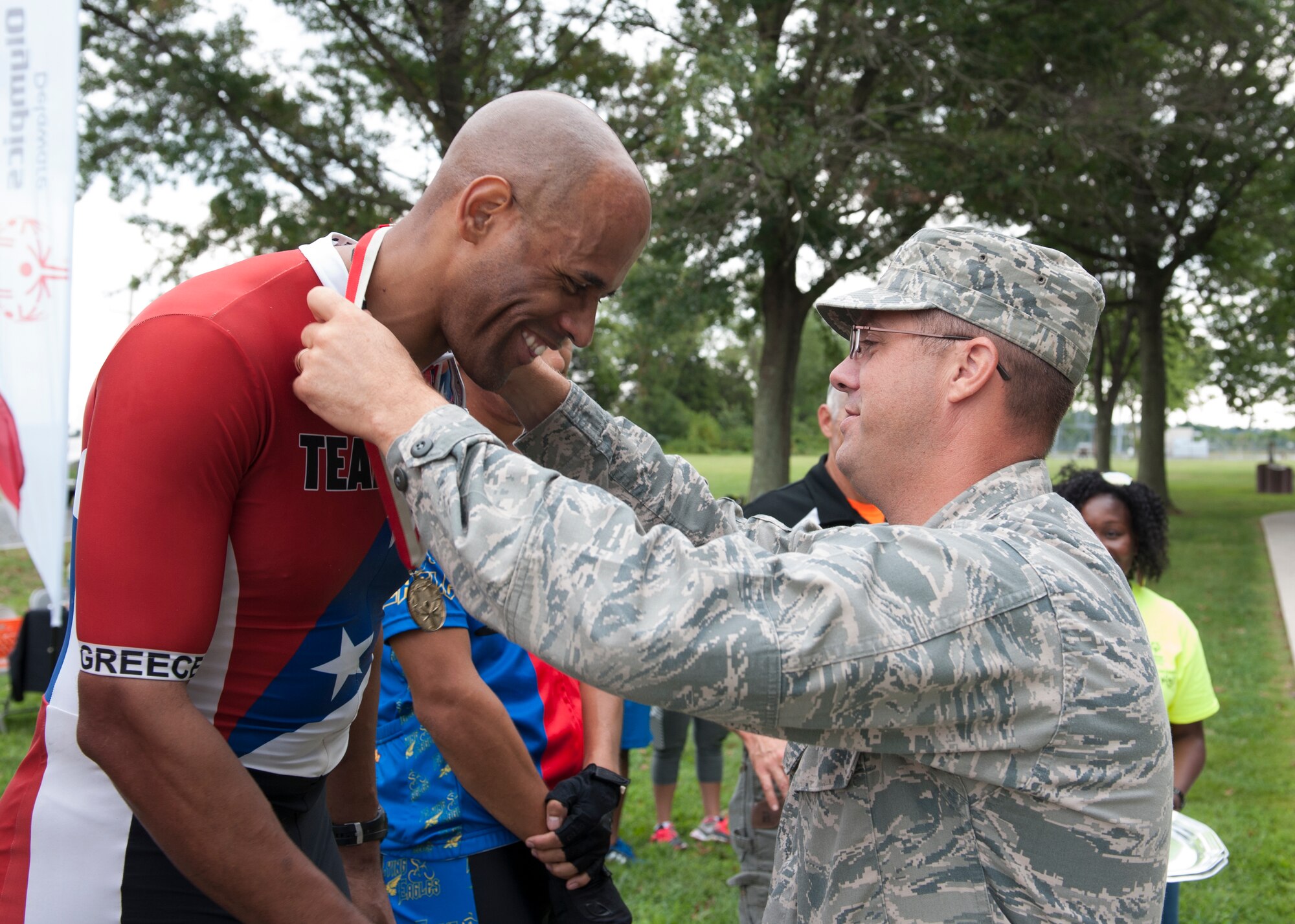 Maj. Danzel Albertsen, 436th Aircraft Maintenance Squadron commander, presents Kenny Jones with a gold medal at the 2015 Special Olympics Cycling Classic Sept. 12, 2015, at Dover Air Force Base, Del. Albertsen presented medals to every cyclist who placed in a race. (U.S. Air Force photo/Airman 1st Class Zachary Cacicia)