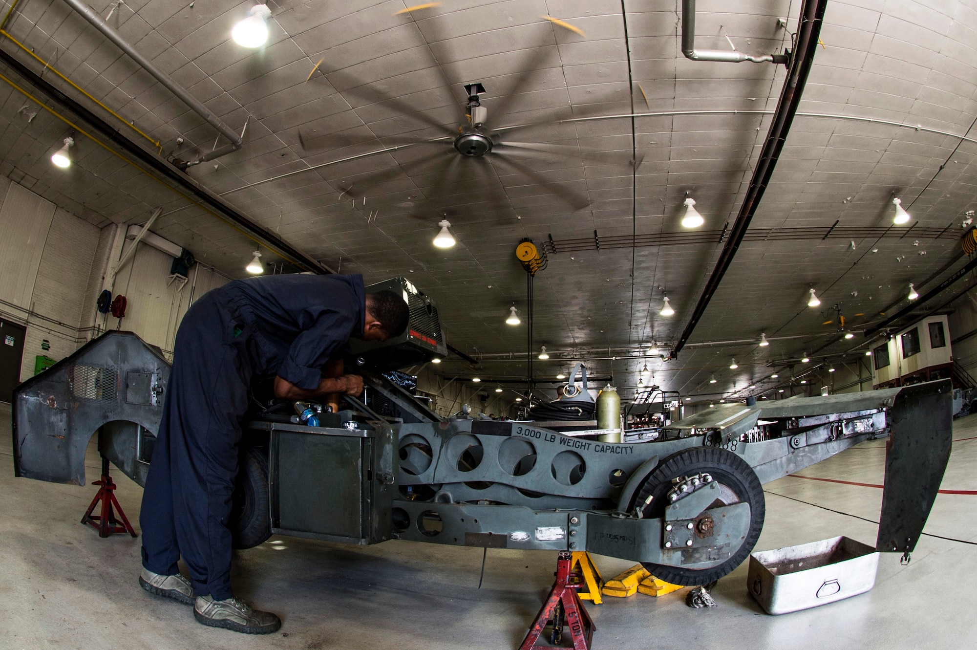 U.S. Air Force Senior Airman Joshua Brown, 1st Maintenance Squadron aerospace ground equipment journeyman, performs preventative maintenance on a bomb lift at Langley Air Force Base, Va., Sept. 9, 2015.  Along with bomb lifts, AGE technicians work on motor and engine-driven generator sets, air conditioners, hydraulic test stands, air compressors and heaters. (U.S. Air Force photo by Senior Airman Kayla Newman/Released)