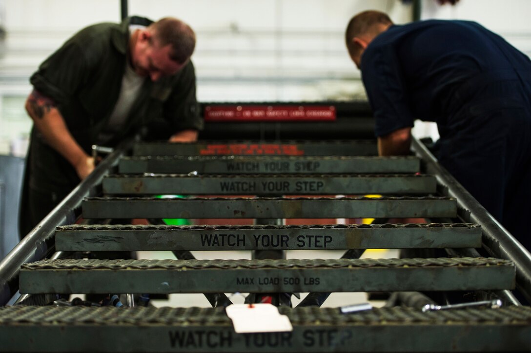 U.S. Air Force Airmen assigned to the 1st Maintenance Squadron aerospace ground equipment flight replace the frame of a B-1 maintenance stand at Langley Air Force Base, Va., Sept. 9, 2015.  The stand is primarily used for high and overhead maintenance or production jobs that are six to 18 feet above the ground. (U.S. Air Force photo by Senior Airman Kayla Newman/Released)