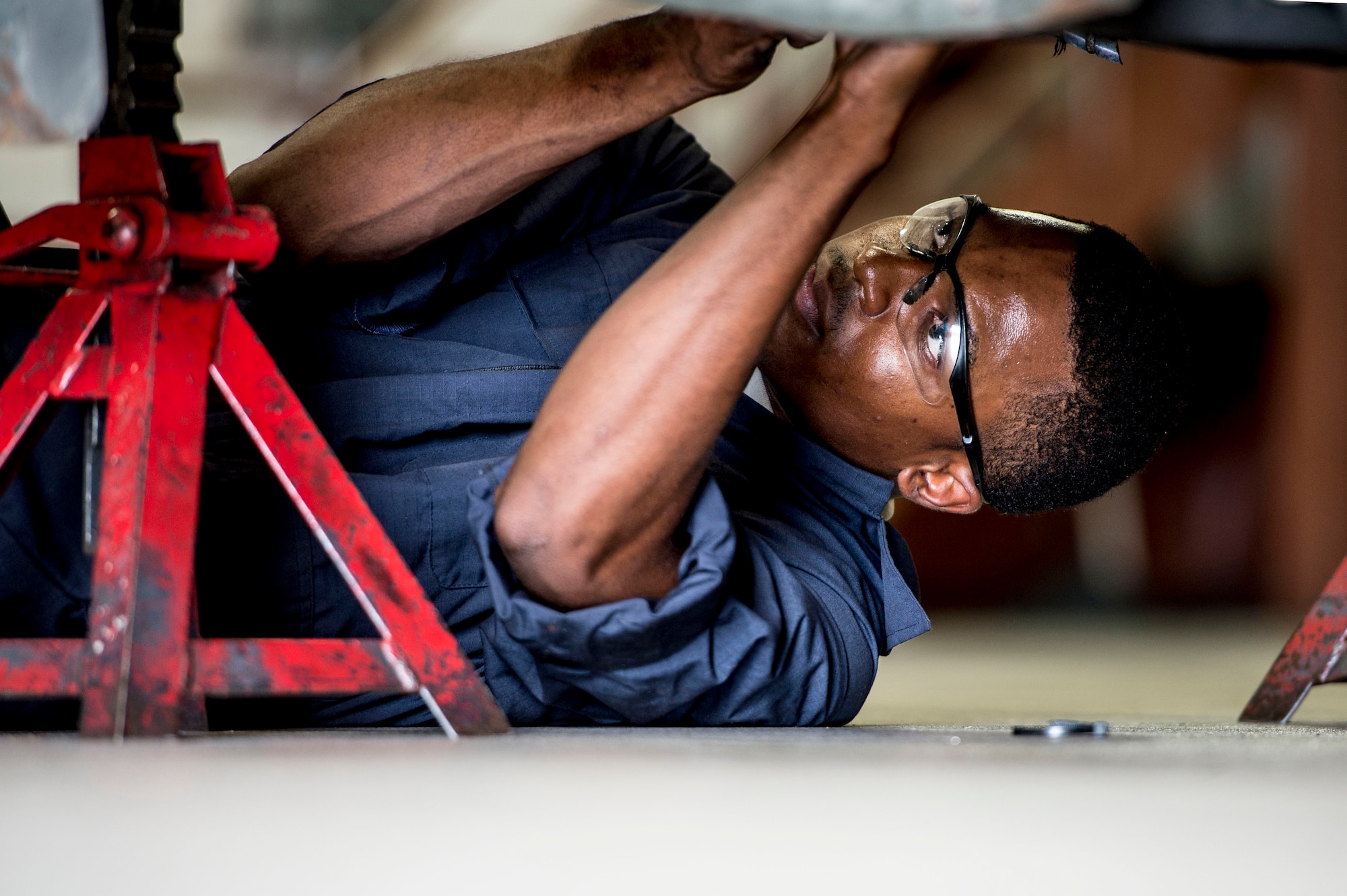 U.S. Air Force Senior Airman Joshua Brown, 1st Maintenance Squadron aerospace ground equipment journeyman, performs preventative maintenance on a bomb lift at Langley Air Force Base, Va., Sept. 9, 2015.  The AGE flight is responsible for servicing, inspecting, repairing and performing preventative maintenance on motor and engine-driven equipment. (U.S. Air Force photo by Senior Airman Kayla Newman/Released)