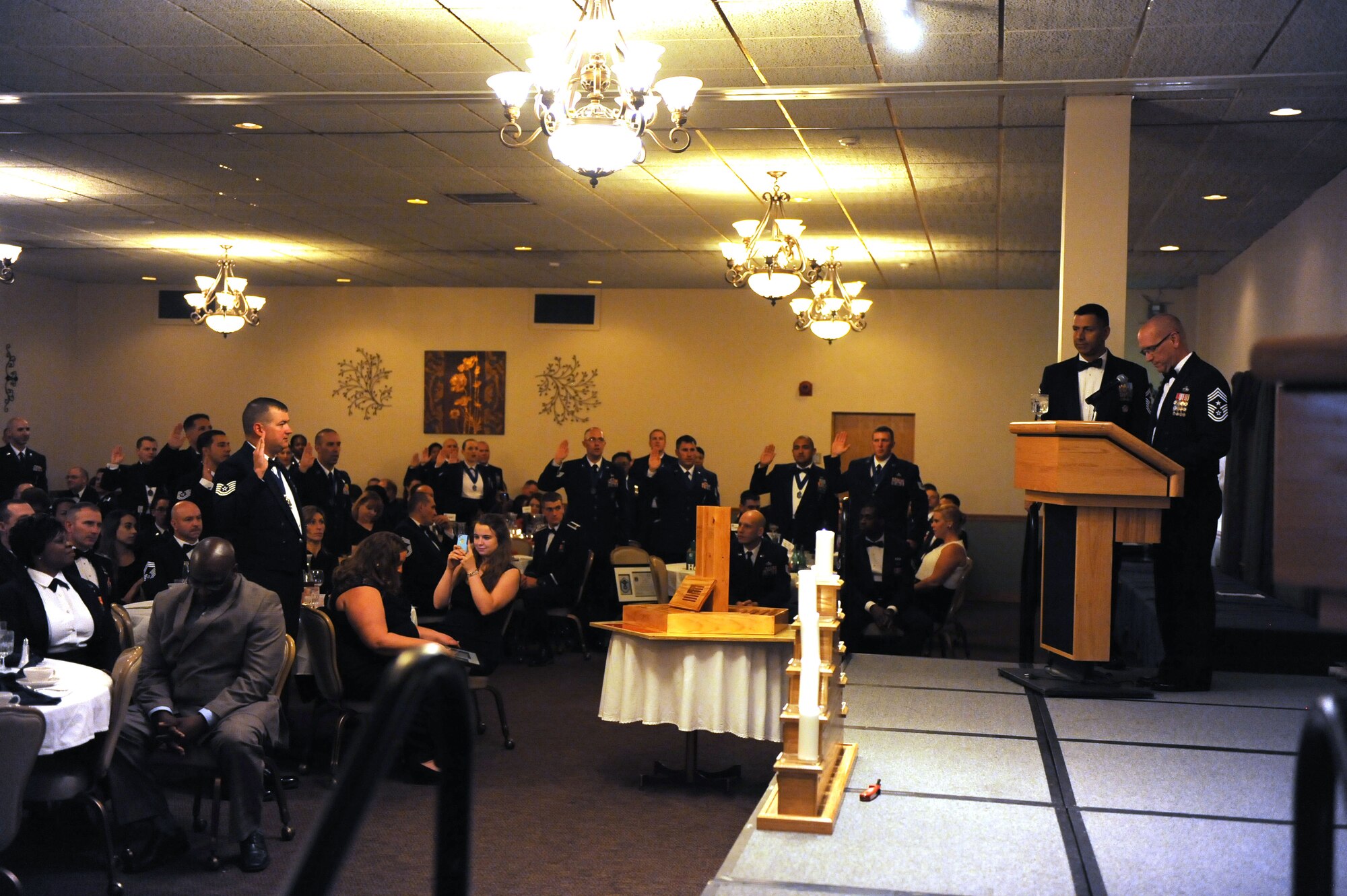 Retired Chief Master Sgt. Brian S. Hornback leads the 52 Senior Non-Commissioned Officer inductees in reciting the Senior Non-Commissioned officer’s Charge at Minot Air Force Base, N.D., Sept. 11, 2015. This event celebrated the ascension of 52 enlisted personnel into the SNCO tier. (U.S. Air Force photo/Senior Airman Kristoffer Kaubisch)
