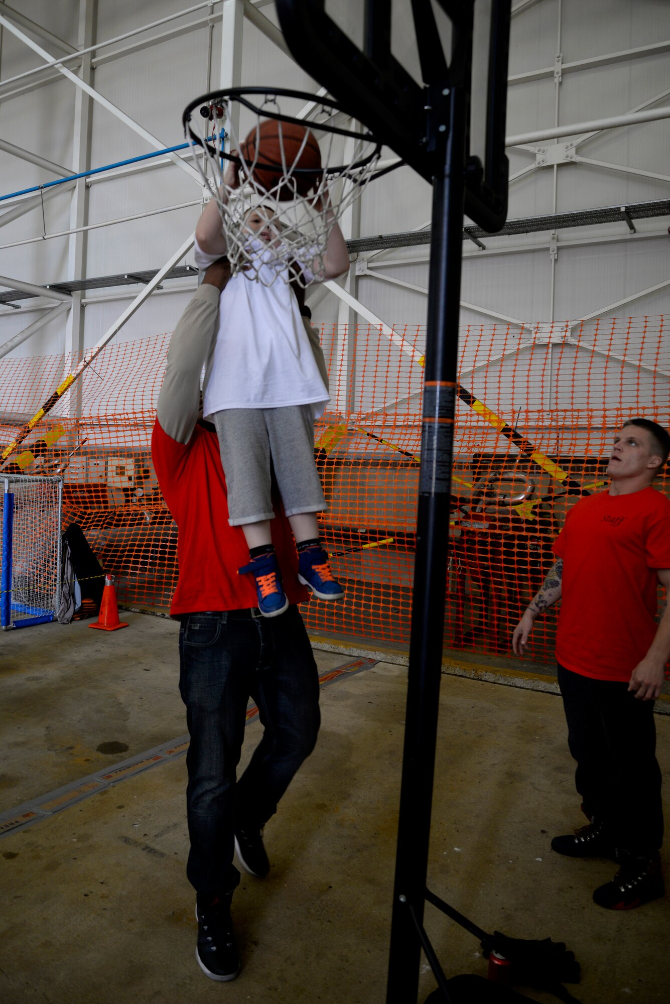 A Joan Mann Special Sports Day athlete shoots a basket with help from a volunteer at the sporting event Sept. 12, 2015, on RAF Mildenhall, England. Approximately 680 volunteers from RAF Lakenheath and RAF Mildenhall participated in the event supporting more than 200 athletes. (U.S. Air Force photo by Senior Airman Victoria H. Taylor/Released)
