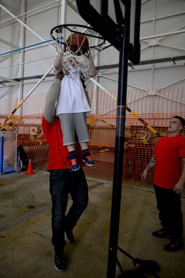 A Joan Mann Special Sports Day athlete shoots a basket with help from a volunteer at the sporting event Sept. 12, 2015, on RAF Mildenhall, England. Approximately 680 volunteers from RAF Lakenheath and RAF Mildenhall participated in the event supporting more than 200 athletes. (U.S. Air Force photo by Senior Airman Victoria H. Taylor/Released)