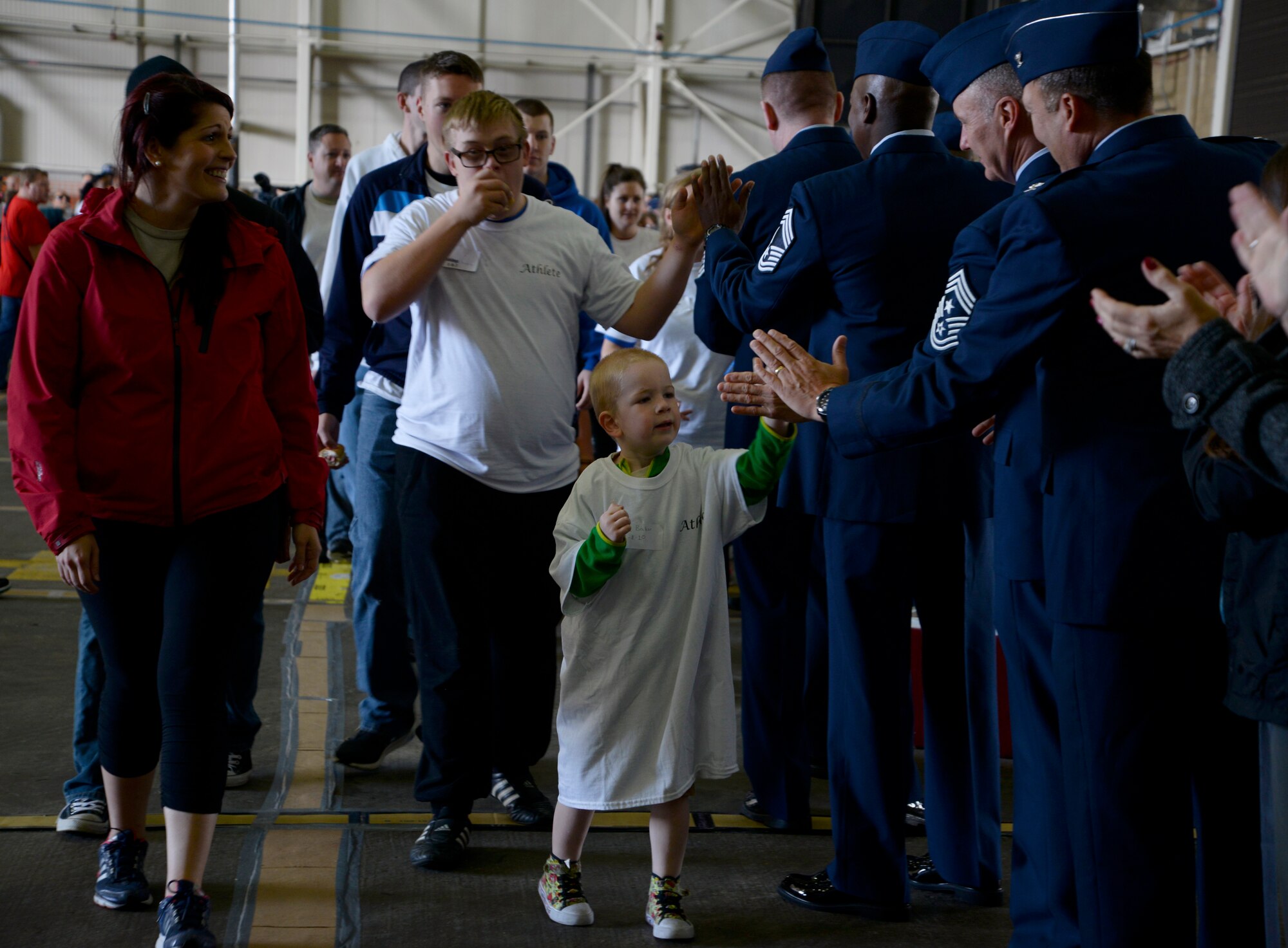 Athletes participating in Joan Mann Special Sports Day greet leadership with high fives during the opening ceremony of JMSSD Sept. 12, 2015, on RAF Mildenhall, England. The event began 34 years ago with Joan Mann, a Ministry of Defence employee on RAF Mildenhall, wanted to find a way to bring local community and military members together to work with special-needs citizens. (U.S. Air Force photo by Senior Airman Victoria H. Taylor/Released)