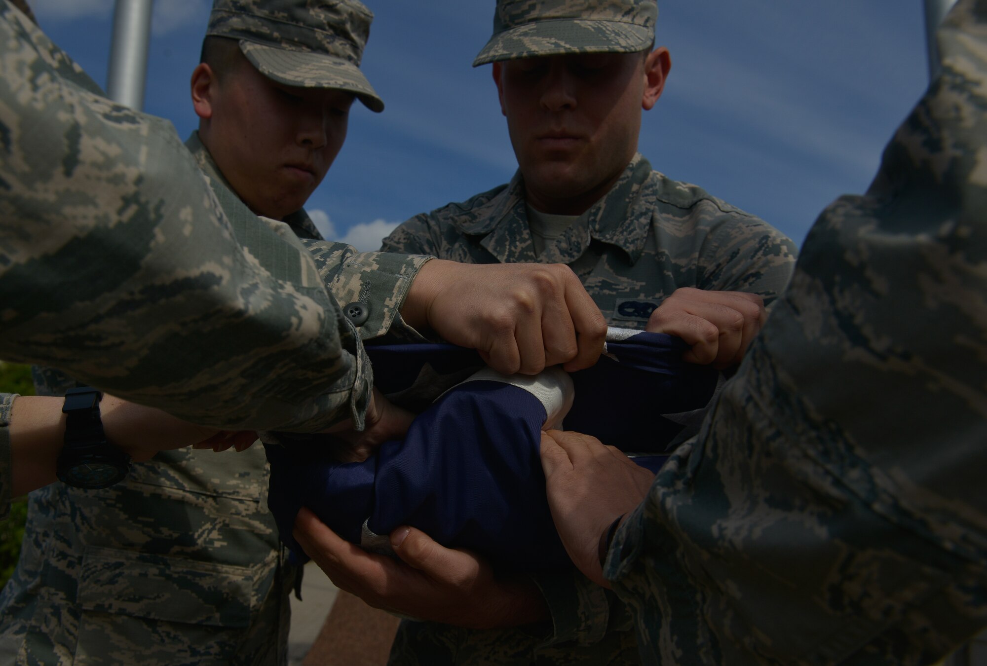 Ramstein honor guardsmen fold the U.S. flag after lowering it during the 9/11 retreat ceremony Sept. 11, 2015, at Ramstein Air Base, Germany. The ceremony honored those who were lost 14 years ago, including the first responders that made the ultimate sacrifice helping individuals escape the collapsing World Trade Center towers.  (U.S. Air Force photo/Airman 1st Class Lane T. Plummer)