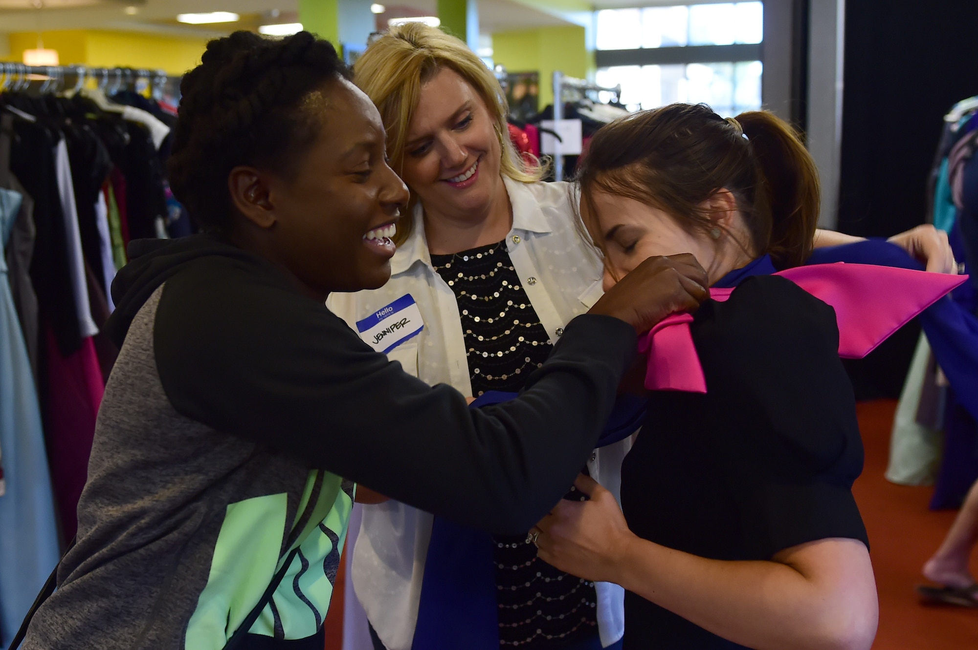 Jennifer Wagner and Kareen Kruzelnick, volunteers at Cinderella’s Closet, help Victoria Kennedy try on a dress Sept. 12, 2015, on Buckley Air Force Base, Colo. Cinderella’s Closet is an event put on by Buckley spouses that provides gently used dresses along with other accessories that can be used for formal events such as military balls. (U.S. Air Force photo by Airman 1st Class Luke W. Nowakowski/Released)  