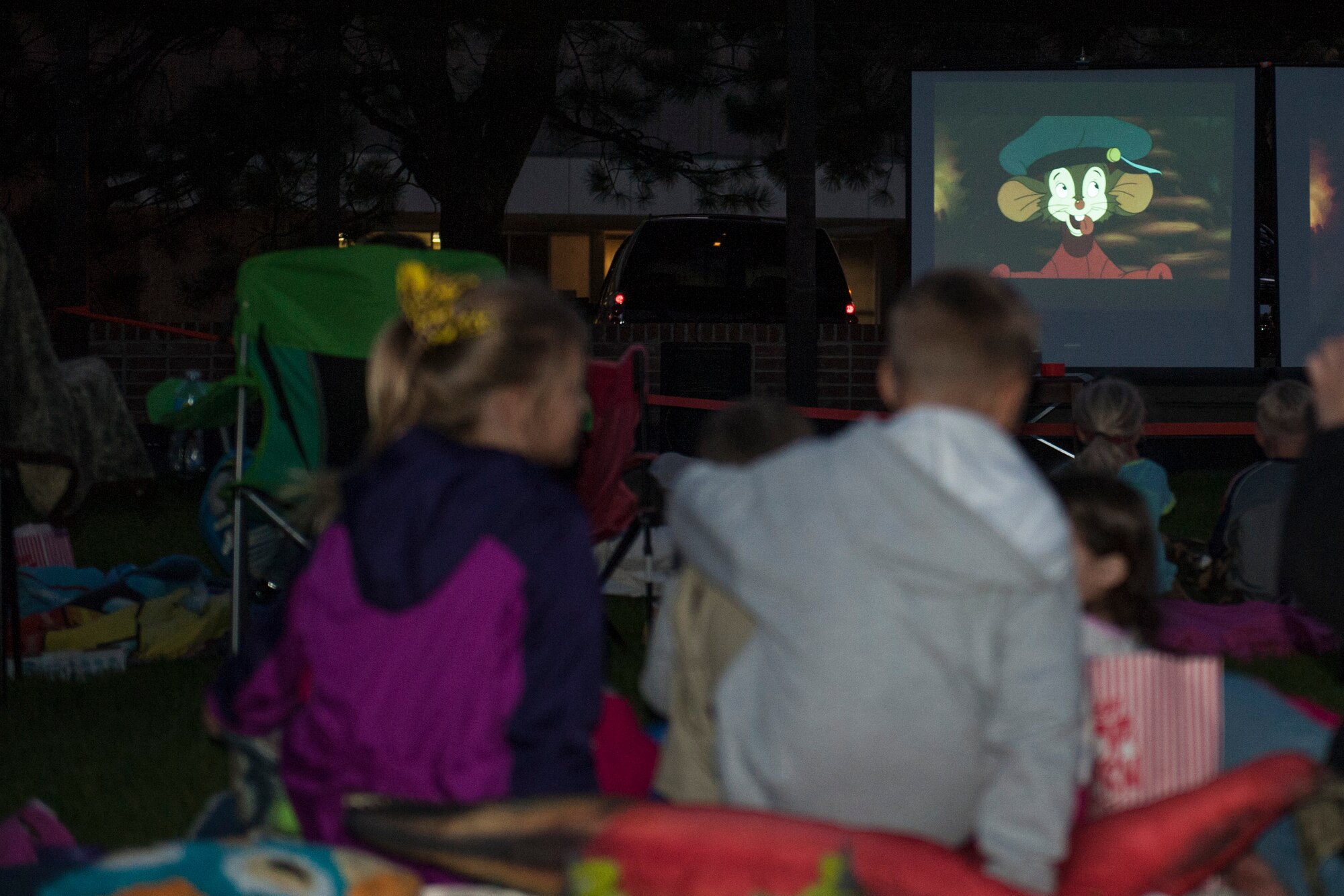 PETERSON AIR FORCE BASE, Colo. – Airmen and their families get comfortable while watching the classic movie “An American Tail” during the Movie on the Lawn event at Patriot Park Sept. 11, 2015. The Base Chapel hosted the event for families to get together before the weather gets cold. They also provided popcorn and candy for movie-goers. (U.S. Air Force photo by Airman 1st Class Rose Gudex)