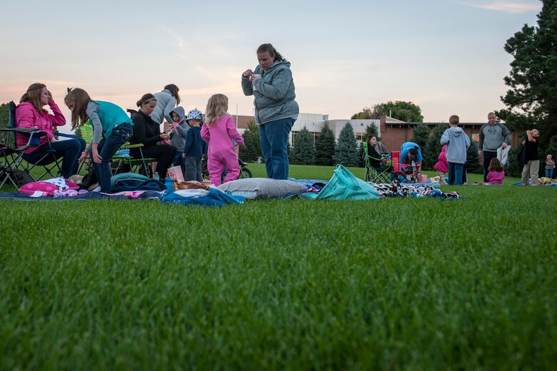 PETERSON AIR FORCE BASE, Colo. – Peterson Airmen and their families get comfortable by laying out blankets and setting up chairs for the Movie on the Lawn event at Patriot Park here Sept. 11, 2015. The event was hosted by the Base Chapel, who provided popcorn, candy, pizza and drinks free of charge to attendees who watched the movie “An American Tail.” (U.S. Air Force photo by Airman 1st Class Rose Gudex)
