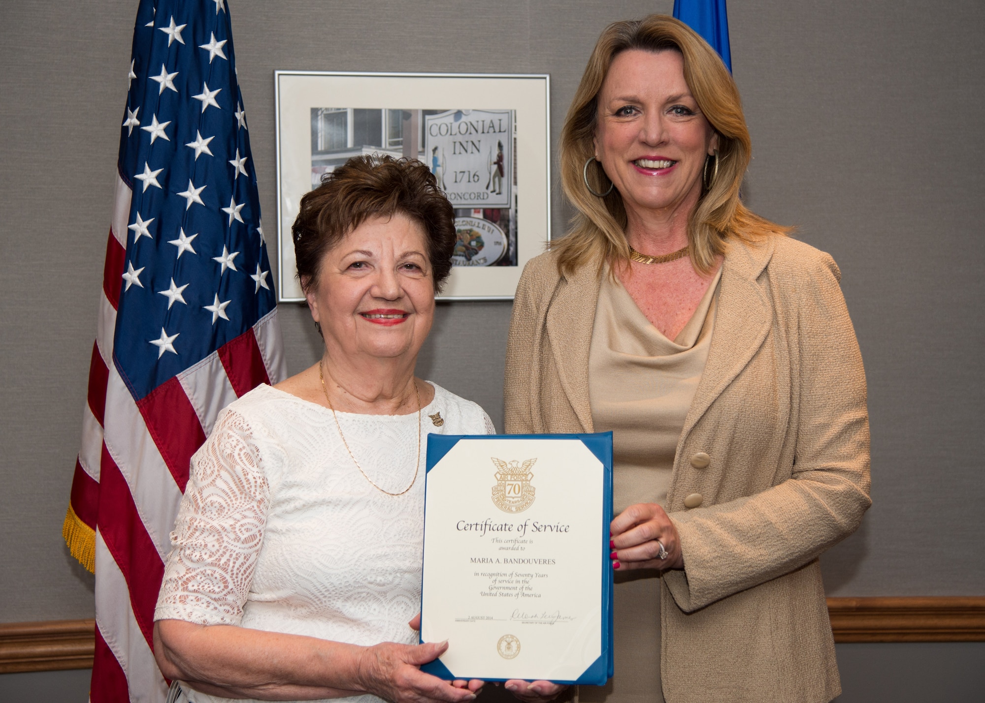 Maria Bandouveres is presented a 70-year federal service pin by Secretary of the Air Force Deborah Lee James during a recognition ceremony in Building 1606 last month. Bandouveres has been federally employed at a myriad of organizations since June 1944. She currently serves as the executive assistant to Maj. Gen. Craig Olson, C3I and Networks program executive officer. (U.S. Air Force photo by Mark Herlihy) 