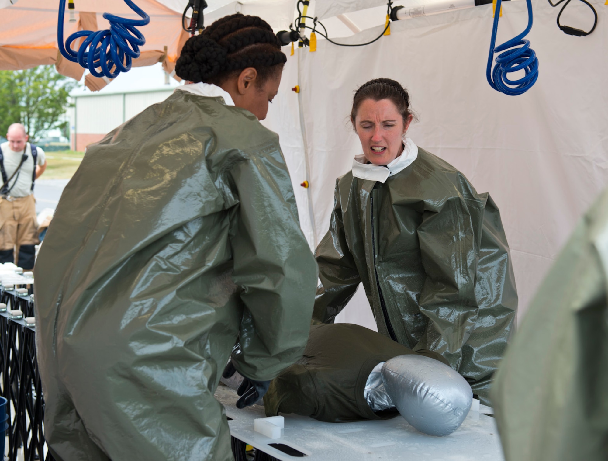 Master Sgt. Nicole Pollard (left) and Tech. Sgt. Helen Wolfley (right), members of the patient decontamination team at the 167th Airlift Wing in Martinsburg, W.Va., conduct decontamination on a litter patient during the Counter-Chemical, Biological, Radiological and Nuclear (CBRN) All-Hazard Management Response (CAMR) Course Table Top Exercise at the wing, August 7, 2015. “The 167th did an amazing job coming together for both the training and all the exercises that took place throughout the week,” said Master Sgt. Gary Fletcher, NCOIC of bioenvironmental engineering at the 167th AW. (Air National Guard photo by Staff Sgt. Jodie Witmer/released)