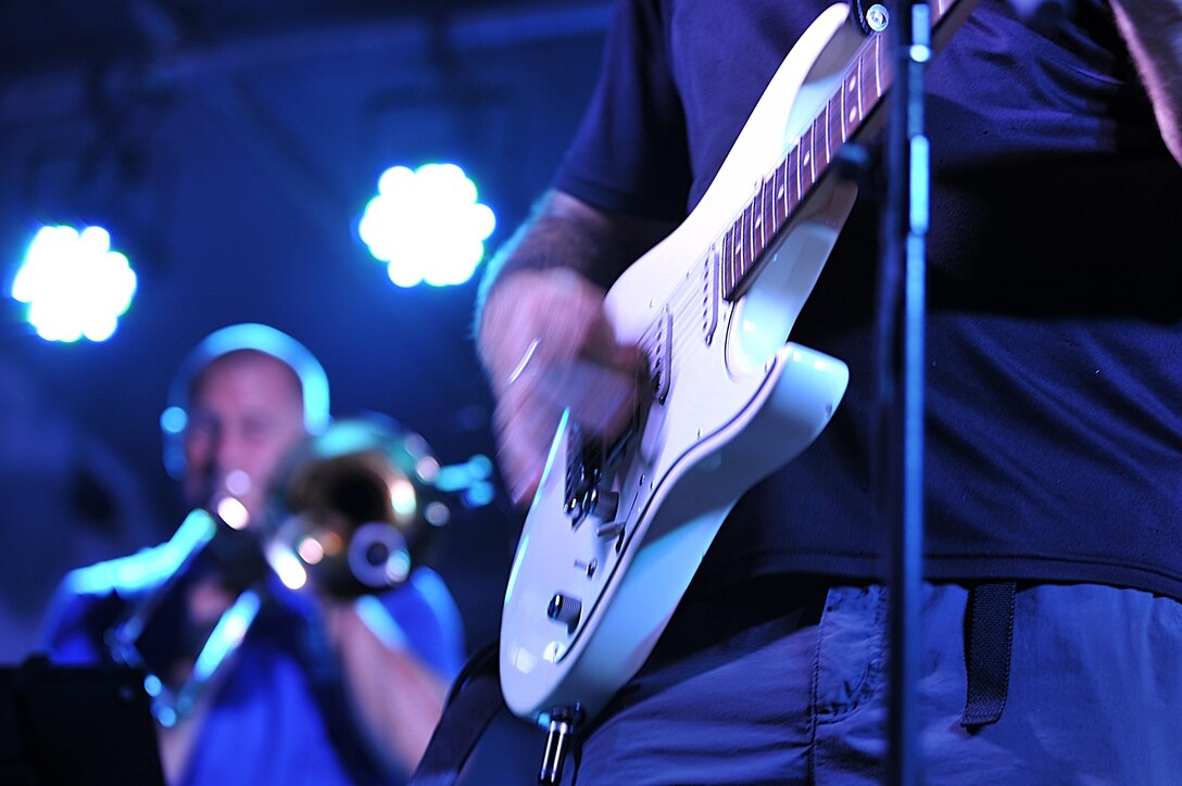 Tech. Sgt. Jason Cale, Air Forces Central Command band guitarist, performs during a concert for service
members at an undisclosed location in Southwest Asia, Aug. 29, 2015. The band uses music as a tool to 
boost troop morale. (U.S. Air Force photo by Staff Sgt. Emerson Nuñez/Released)
