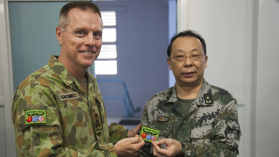 Brigadier Damian Cantwell, deputy commander of the 2nd Division, Australian Army (left), presents Maj. Gen. Han Peng, chief of staff, Guangzhou Military Region, People’s Liberation Army with the Exercise Kowari 2015 patch before the exercise’s closing ceremony Sept. 12, 2015 at Larrakeyah Barracks, Darwin, Northern Territory, Australia. In its second iteration, Kowari 15 was a trilateral environmental survival training opportunity hosted by Australia and included forces from the U.S., Australia and China simultaneously. 